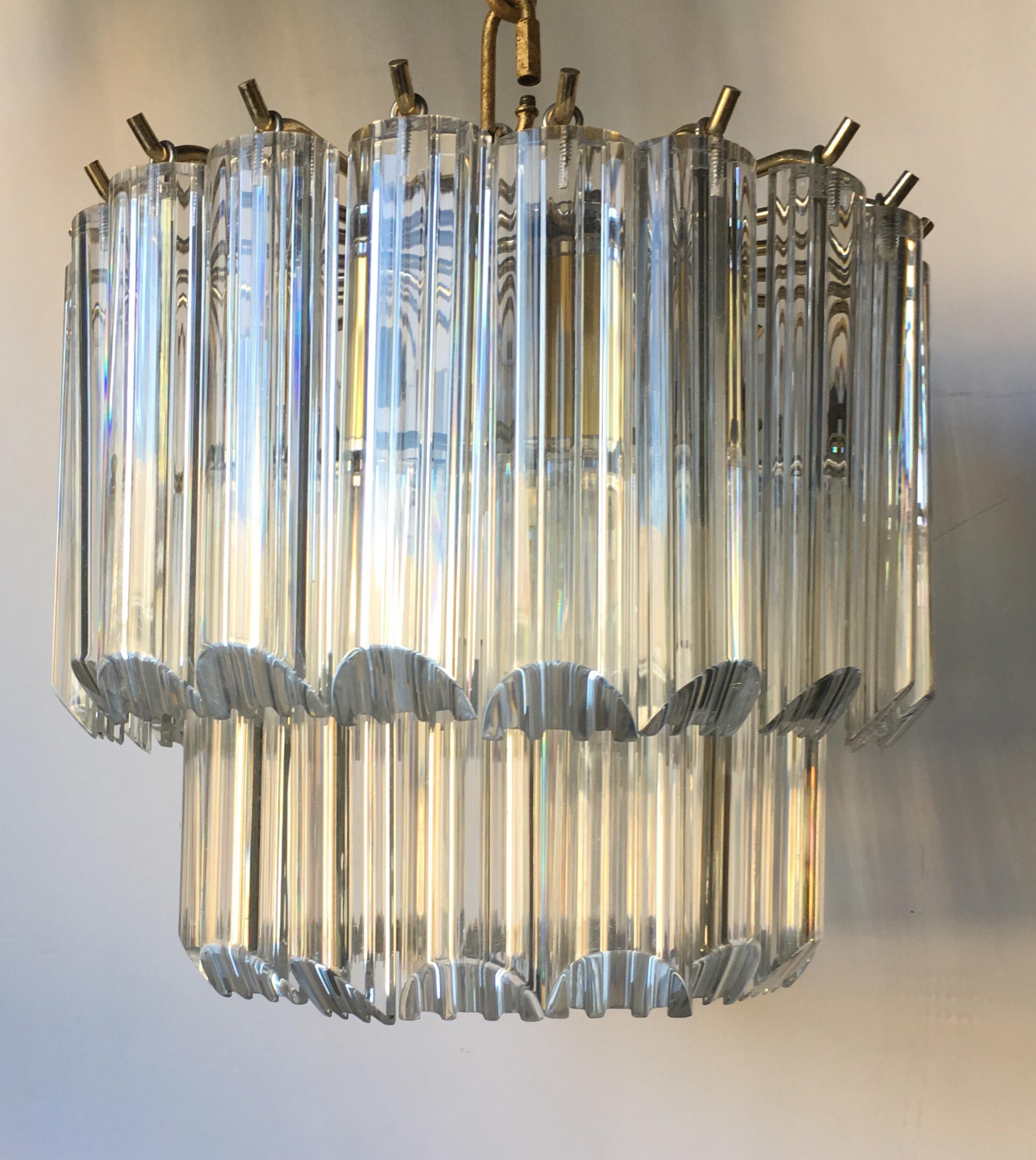 Petite Mid Century Modern 2-tier Lucite waterfall chandelier. Light fixture features a nice quality weighted polished chrome and brass frame with clear Lucite ribbed prisms. Perfect size for a small hallway or powder room.
Fixture takes four candle