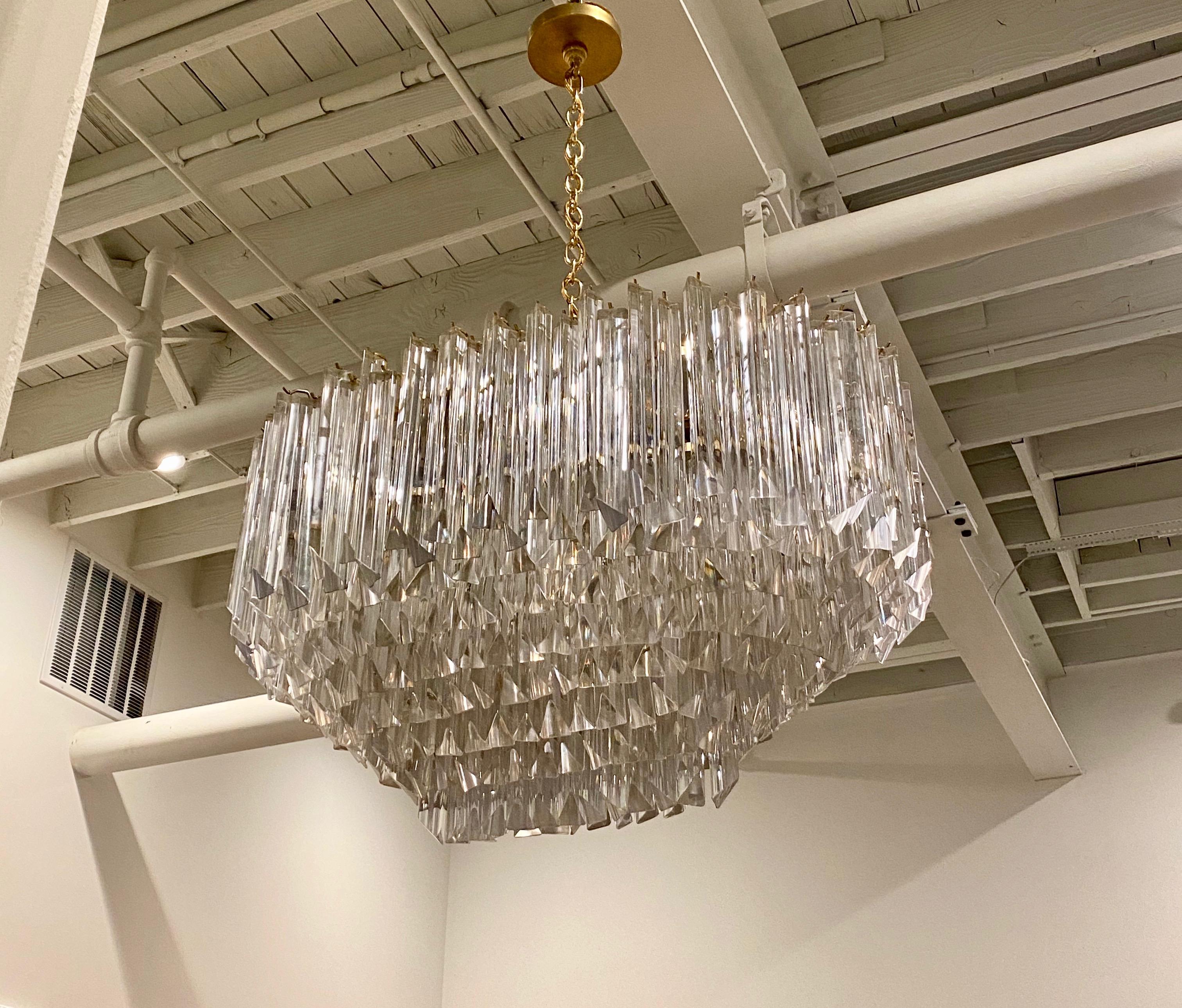 Mid-Century Modern oval tiered chandelier. Each of the prisms are solid glass. They hang from hooks on a brass (gold) frame as pictured. The chandelier has been rewired for American use with fourteen medium base sockets. Any amount of chain can be