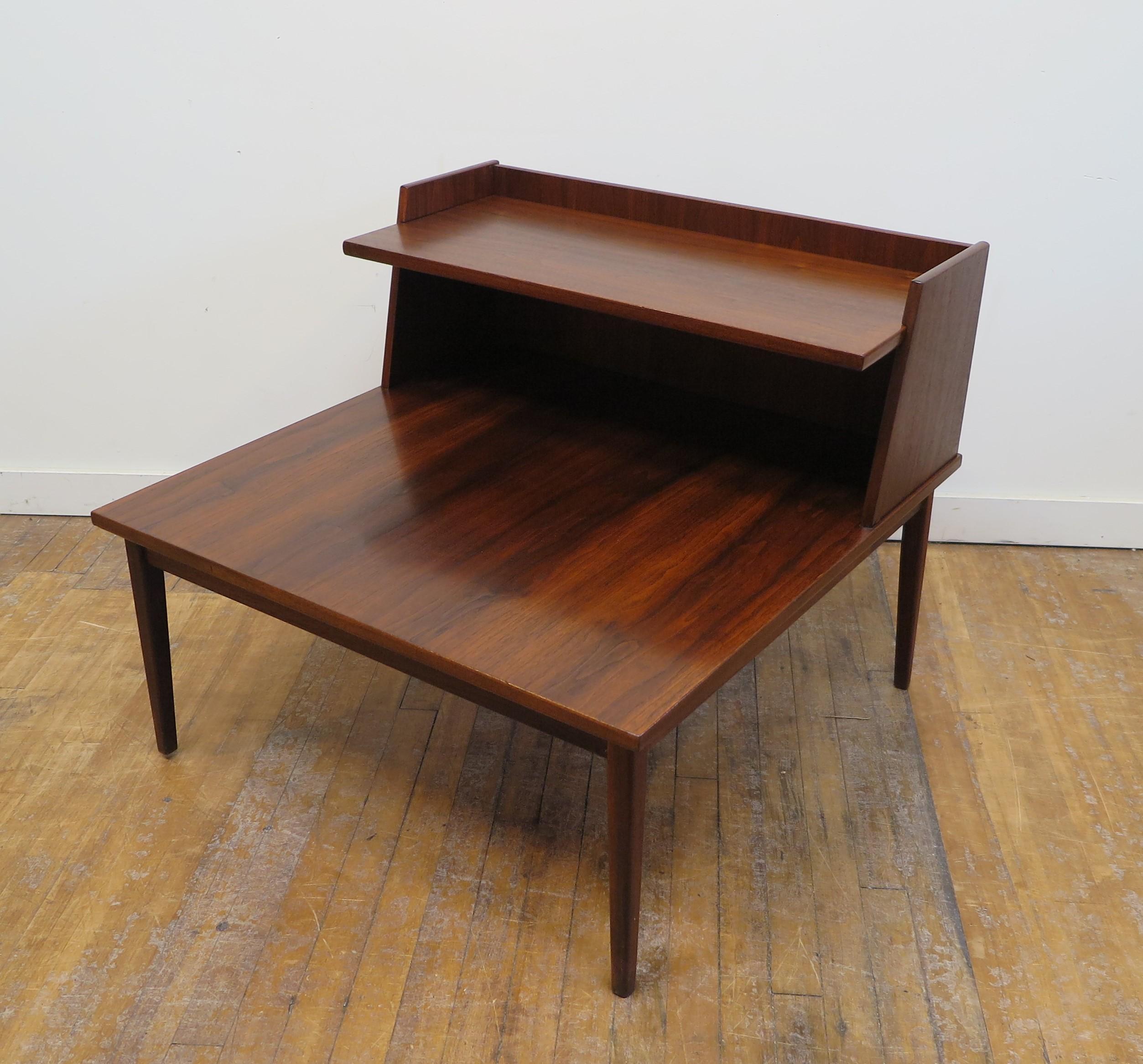 Danish Modern Teak Mid Century side table. Mid-Century Modern Side table with an upper shelf. Very nice shelfed side table in teak. The lower main shelf is 16 inches high and the rear upper shelf is 24 inches high. This is larger footprint table
