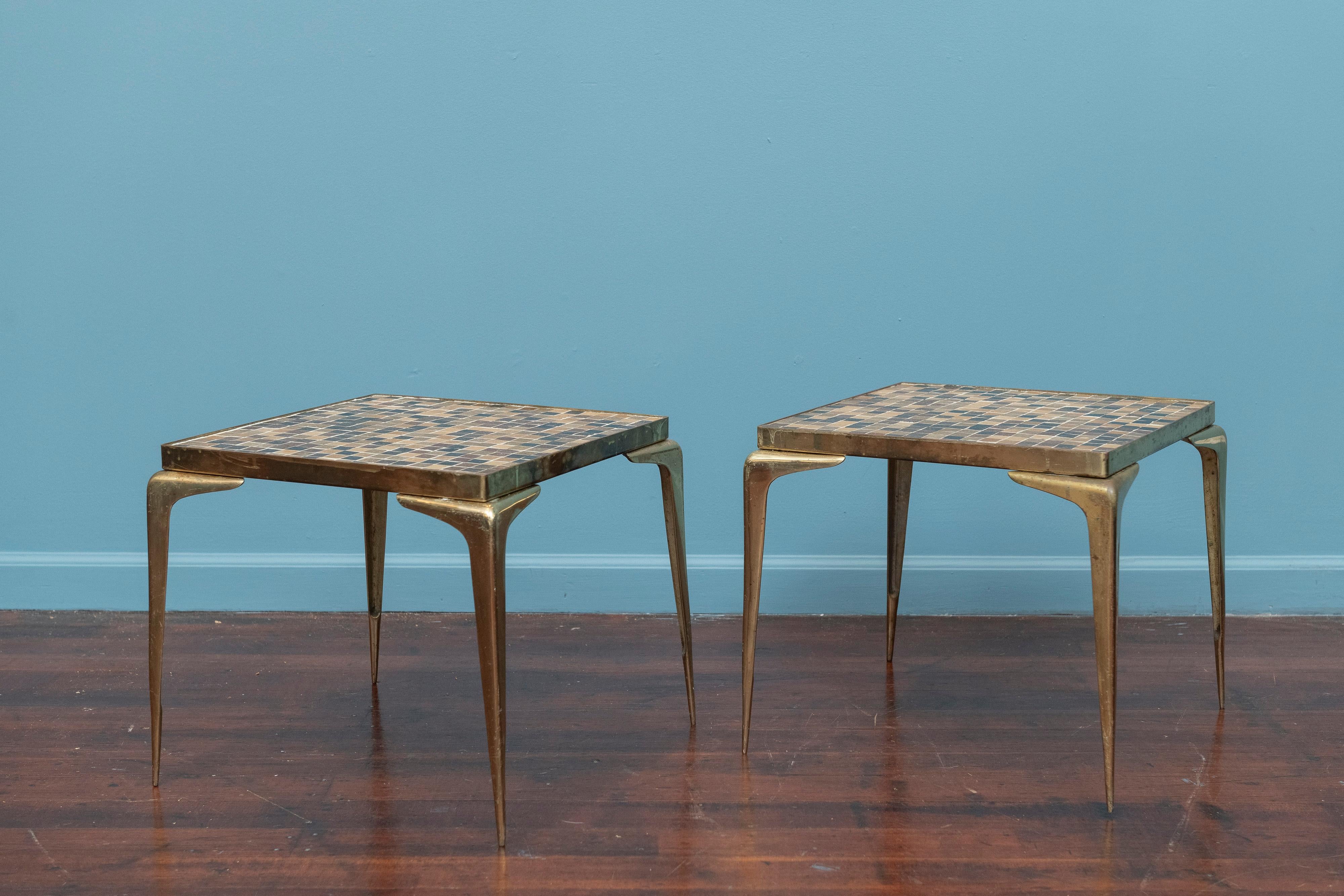 Pair of mid-century modern mosaic tile top side tables in brass frames with saber legs. Possibly Murano glass tiles inlaid in a random pattern, great for indoor or outdoor use. In good condition with patina throughout. 