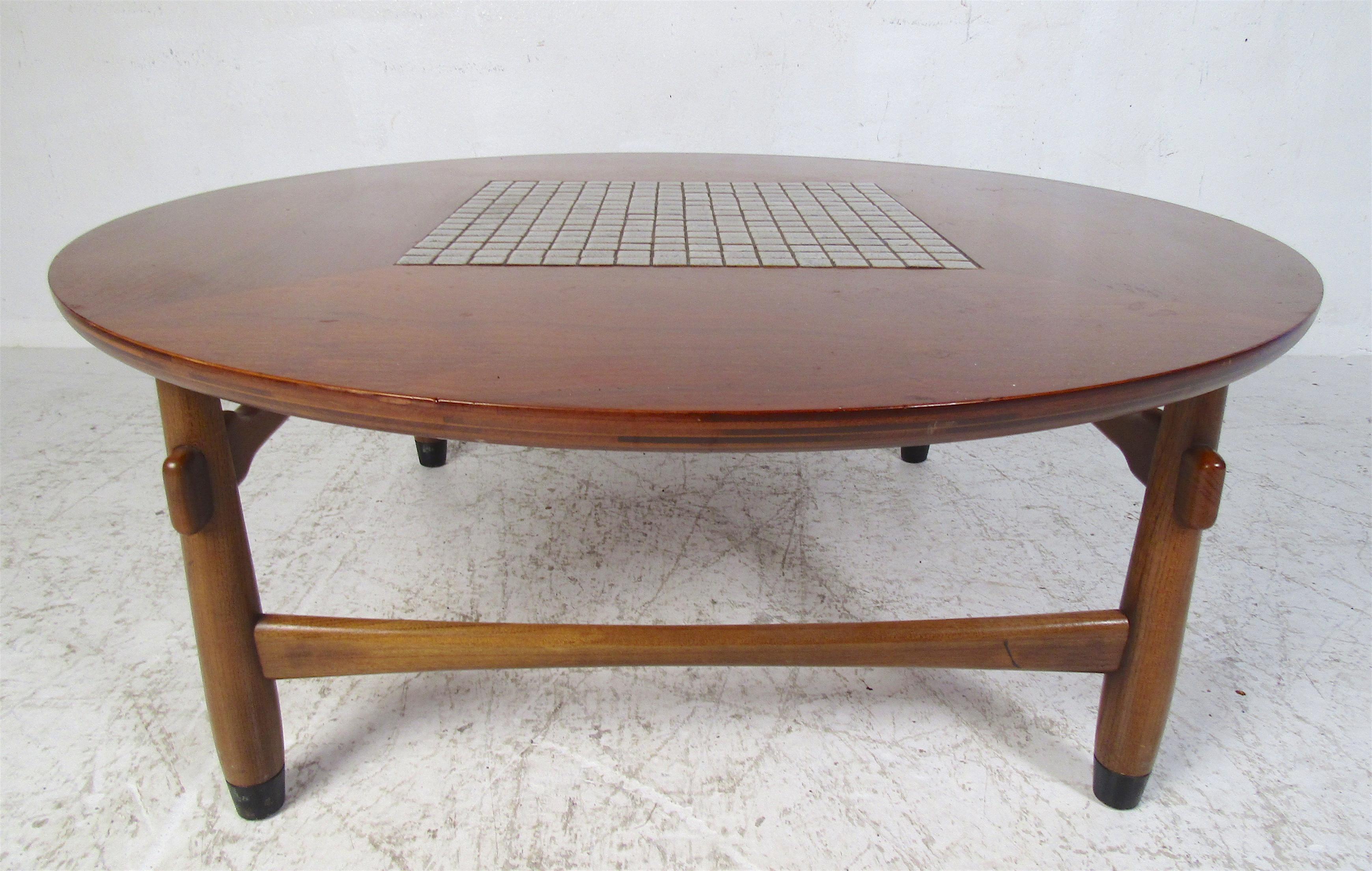 This stunning vintage modern coffee table by Lane features a unique tiled center and a walnut frame. This circular coffee table has four legs connected by sculpted stretchers. A sleek design that looks great in any modern interior. Please confirm