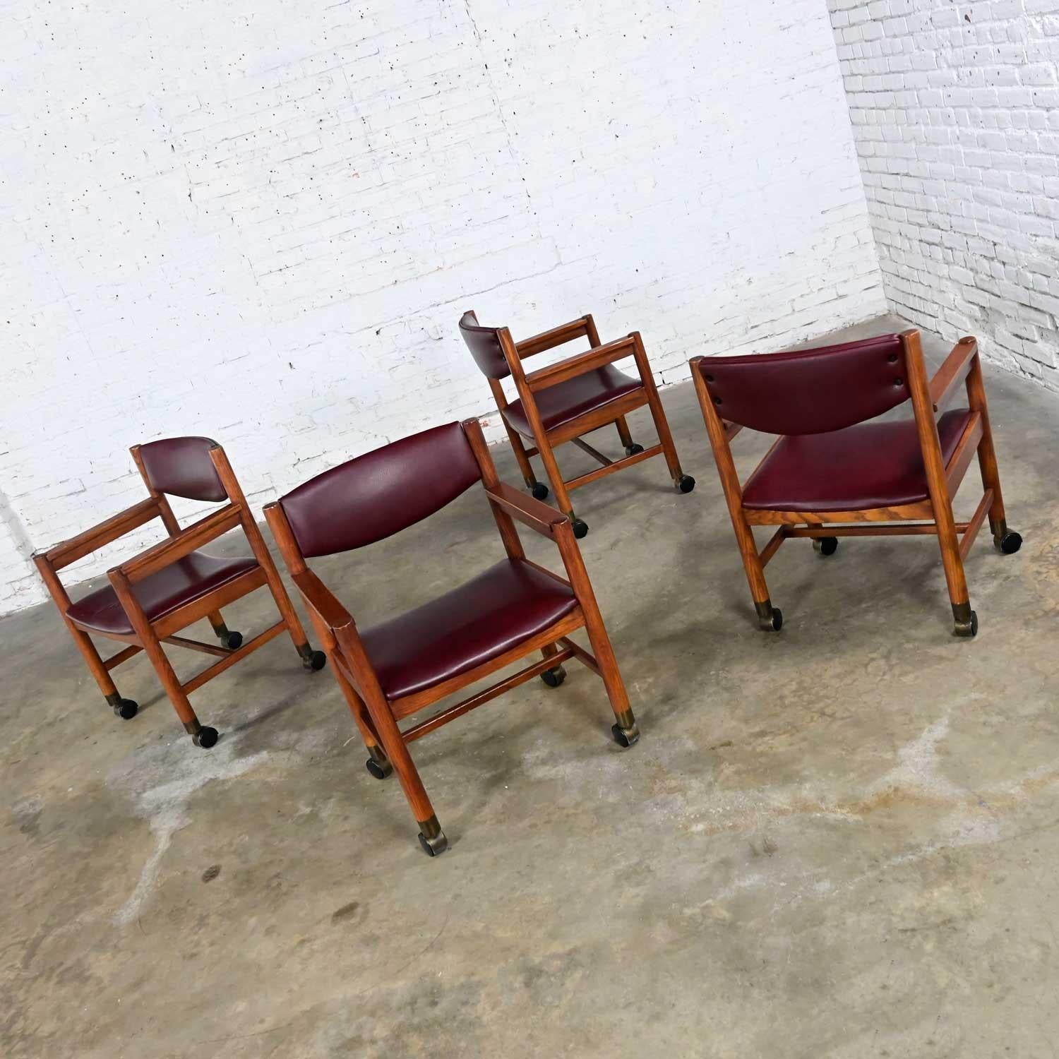 Mid-Century Modern to Modern Oak Maroon Vinyl Rolling Game or Dining Chairs In Good Condition For Sale In Topeka, KS
