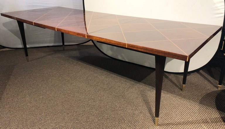 A Charak Modern for Tommi Parzinger tagged dining table with two leaves in mahogany. Part of our extensive collection of over forty dining tables and chair sets as seen on this site, thus why we are referred to as the King of Dining rooms.
 
 
This