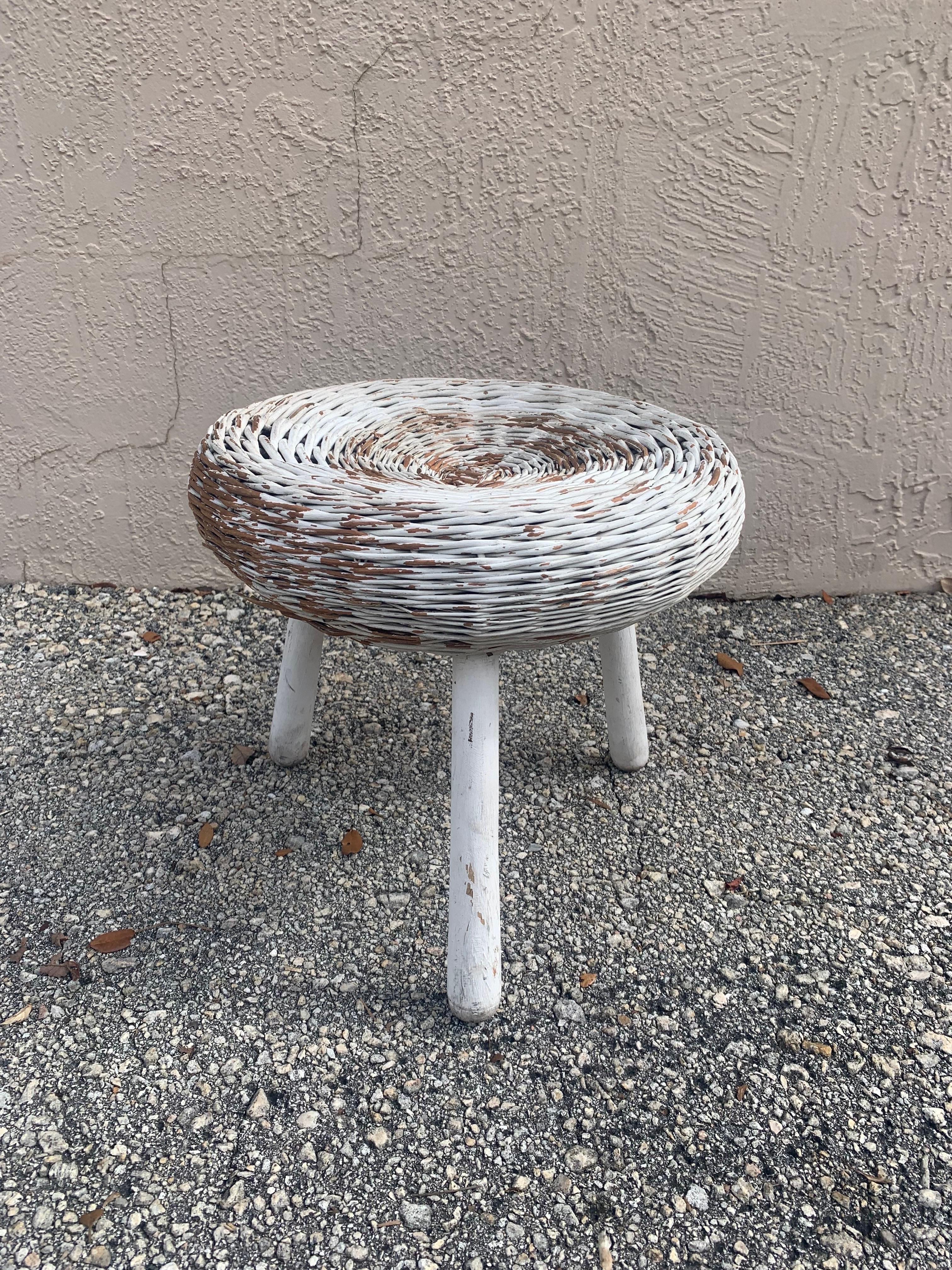 Mid-Century Modern vintage organic stool made from woven rattan and solid wood. Attributed to Tony Paul and made in the United States 1950s. 

Conical legs of solid wood support the wicker top. The piece has been painted white years and years ago
