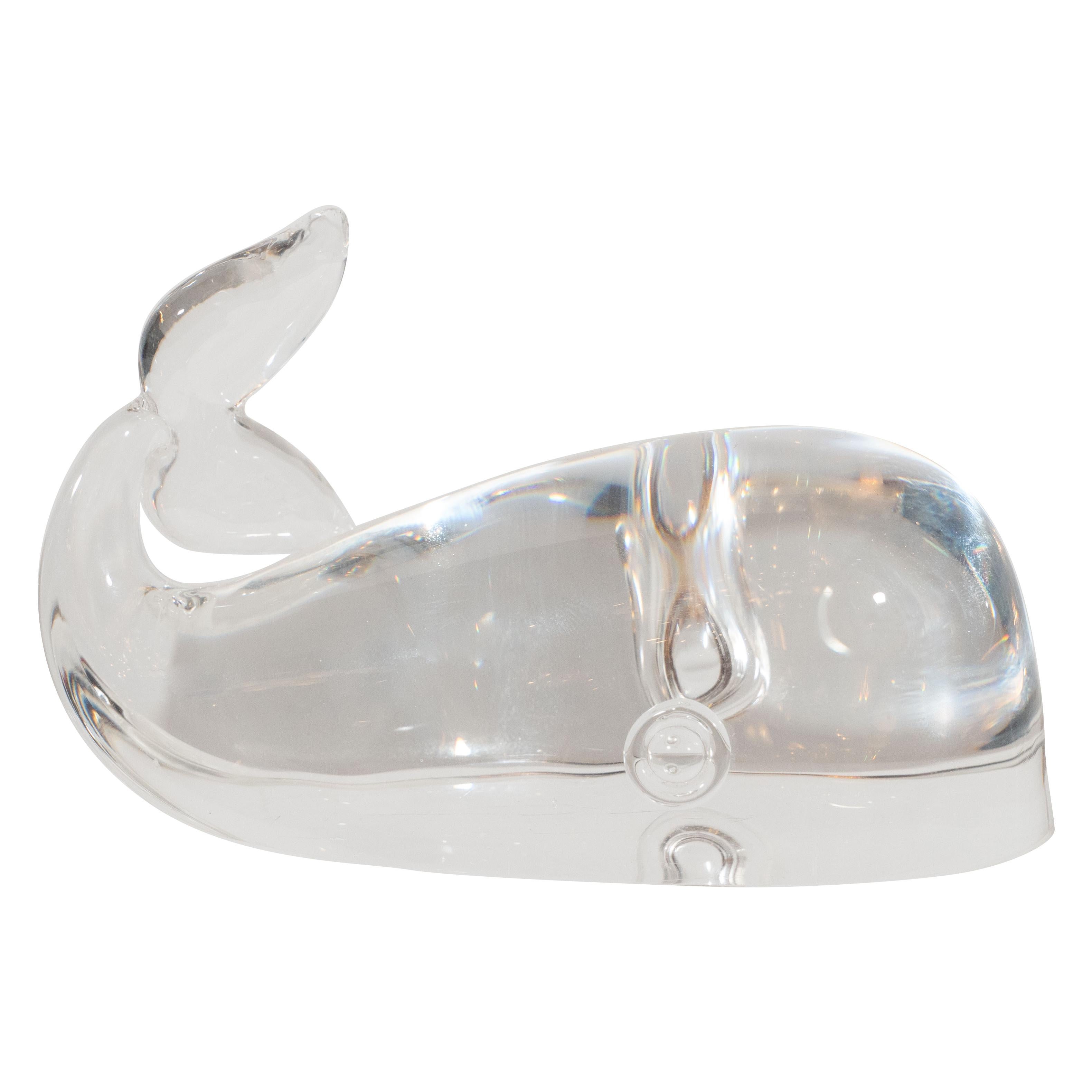 This elegant glass paperweight was created by Steuben Glass Works- one of America's premiere glass studios, since its founding in 1903-circa 1960. It offers a stylized and abstracted rendition of a Beluga whale with its notched tail curling behind