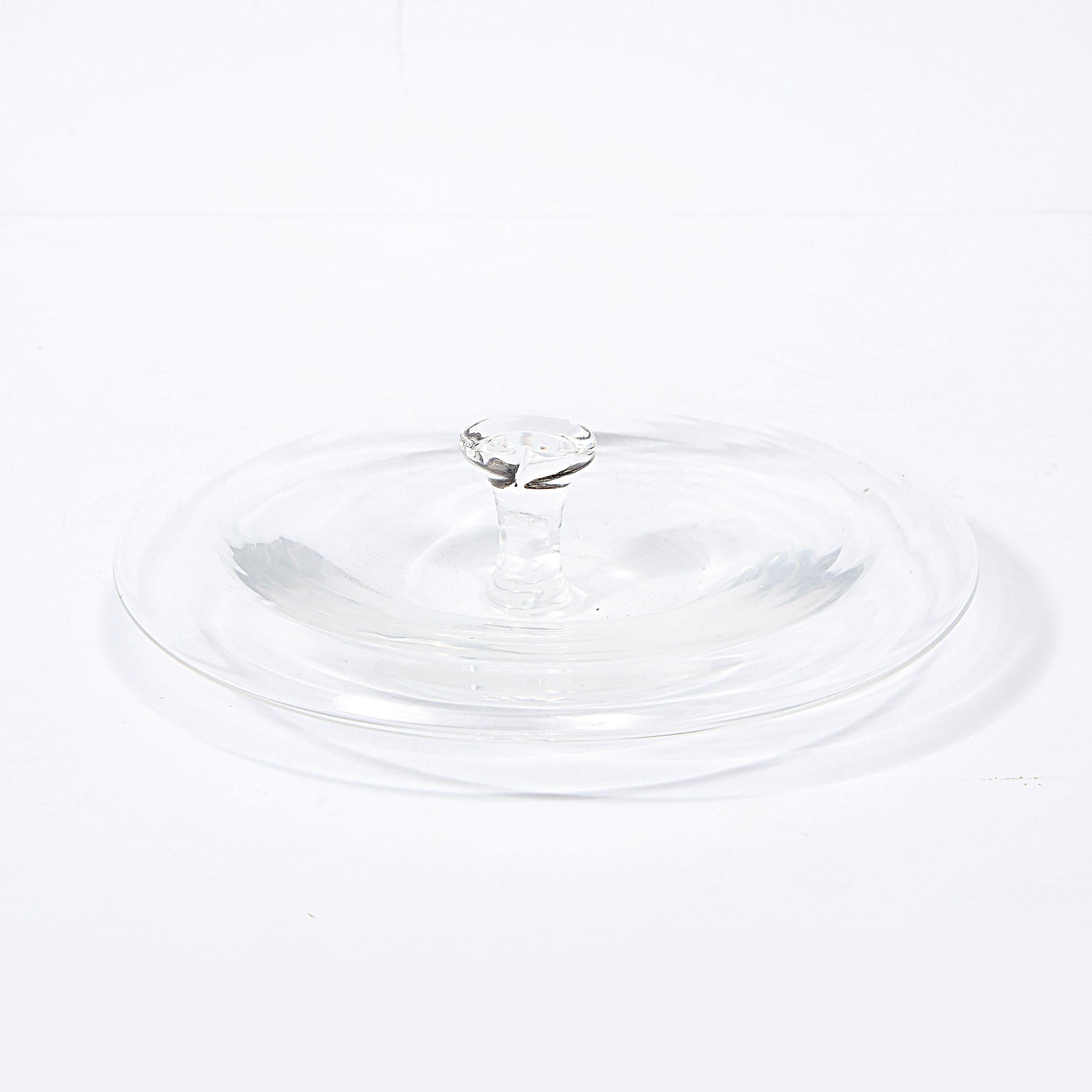 Part of Elsa Peretti iconic Thumbprint collection for Tiffany & Co, this translucent glass decorative dish/ ash tray was designed in 1978, and executed shortly thereafter. Peretti, an Italian fashion model, turned designer and philanthropist started