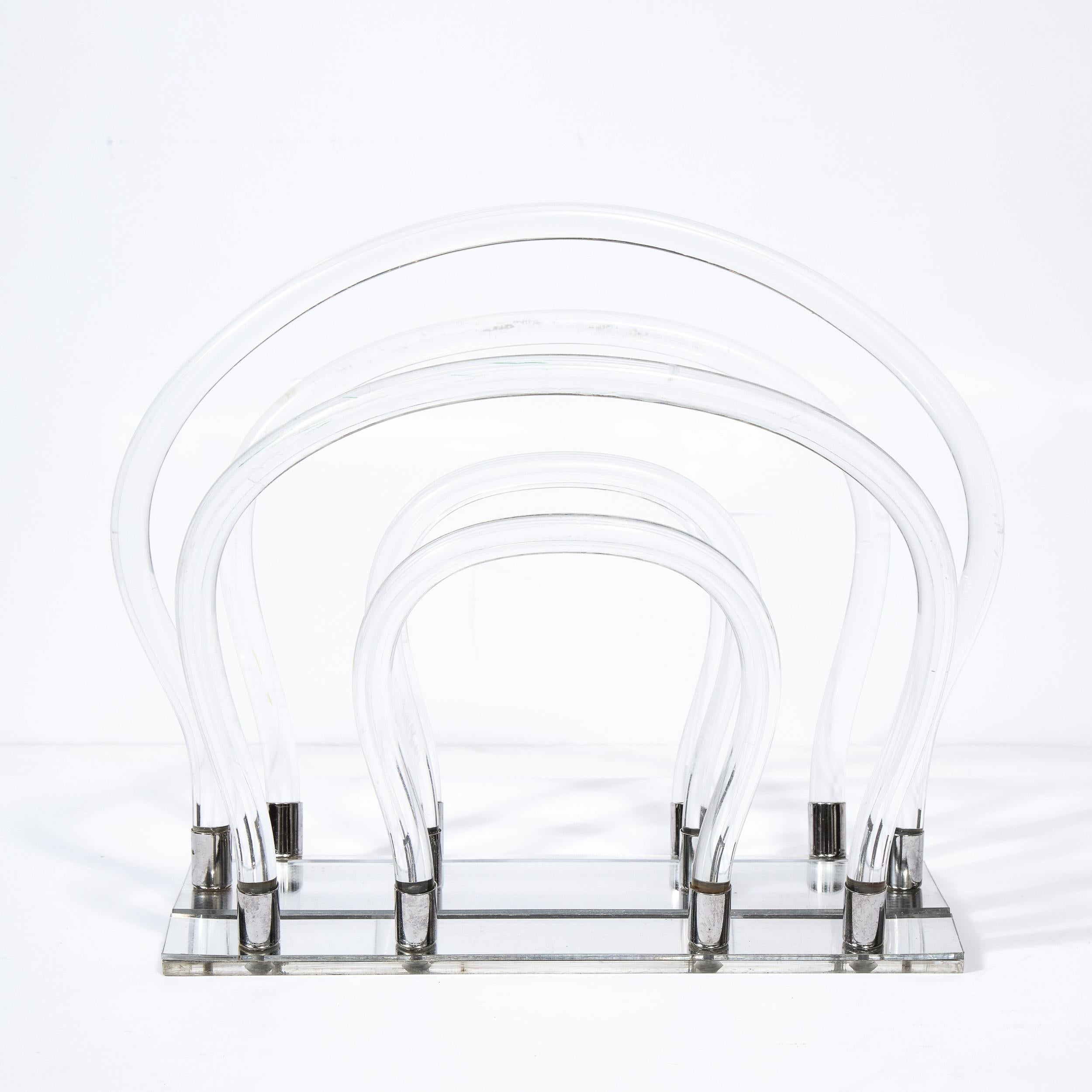 This stunning magazine stand was realized by the illustrious Dorothy Thorpe in the United States circa 1970. It features concentric amorphic forms realized in translucent Lucite with chrome fittings and a mirrored Lucite base. With its clean lines