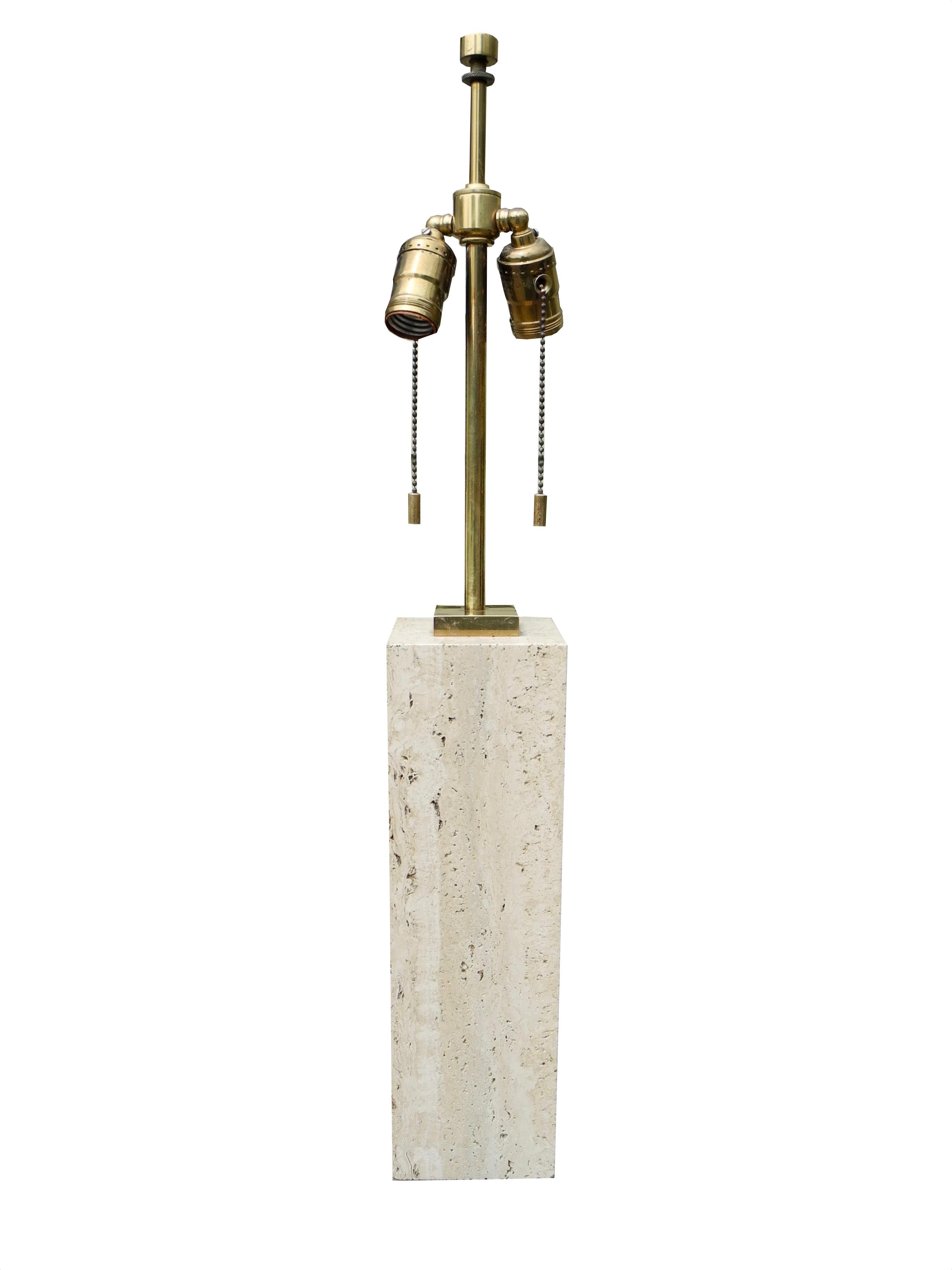 This block of solid travertine stone with brass hardware and fittings was designed by TH Robsjohn-Gibbings in the 1950s. Its design is handsome and modern. The stone measures 4 x 4 x 13.5 inches. The height to the top of the finial is 27.25