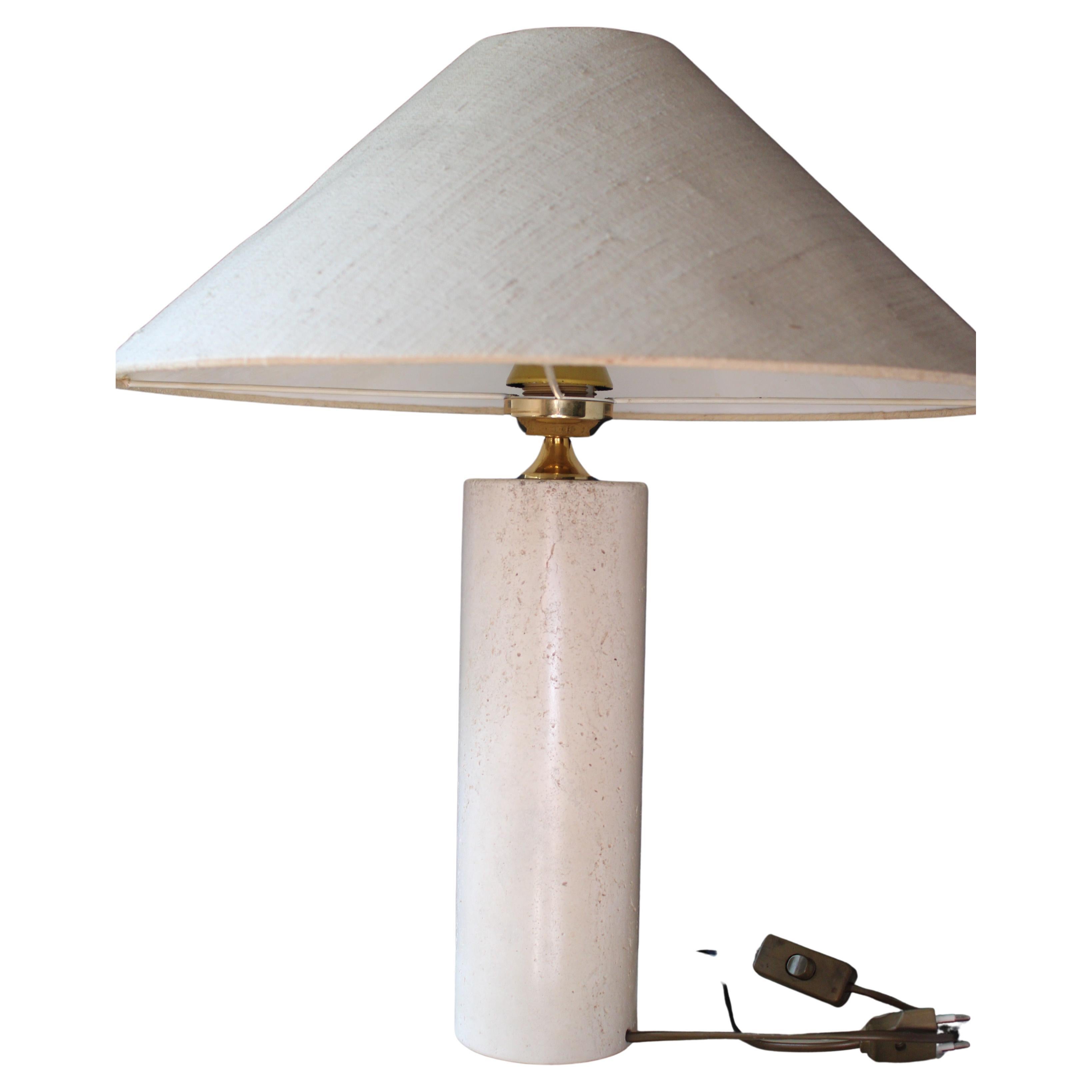 Cette lampe minimaliste en bloc de travertin avec son abat-jour original en lin de couleur avoine dégage une élégance intemporelle. 

Bien que plus légère que le marbre, la base cylindrique est assez lourde et conserve un aspect et une sensation de