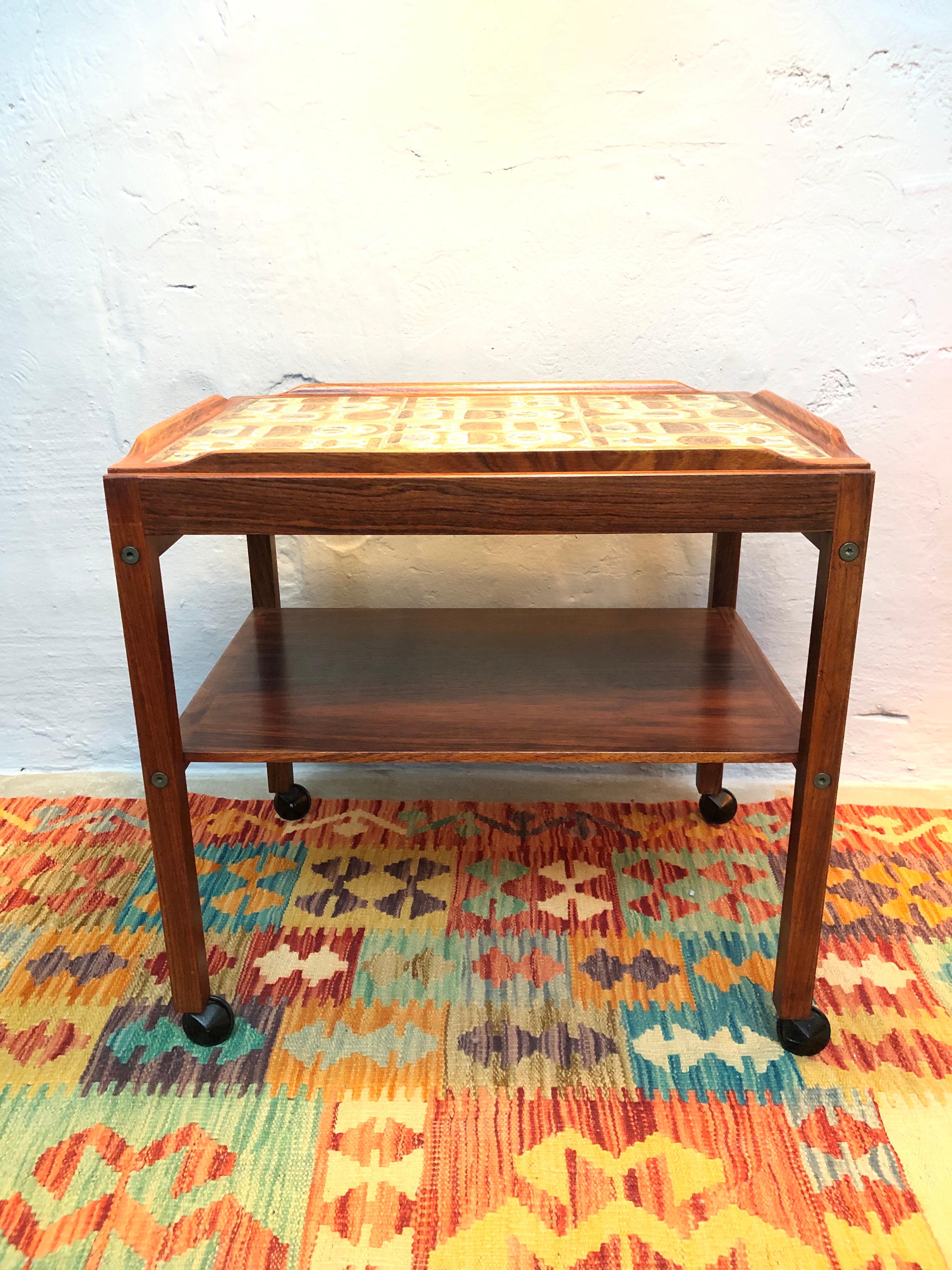 Vintage Mid-Century Modern tray table in rosewood and with inlaid Royal Copenhagen faience tiles.
Marked on the underside of the tray with a ceramic label.
In great unrestored vintage condition.
A little beautiful and rare gem of a tray
