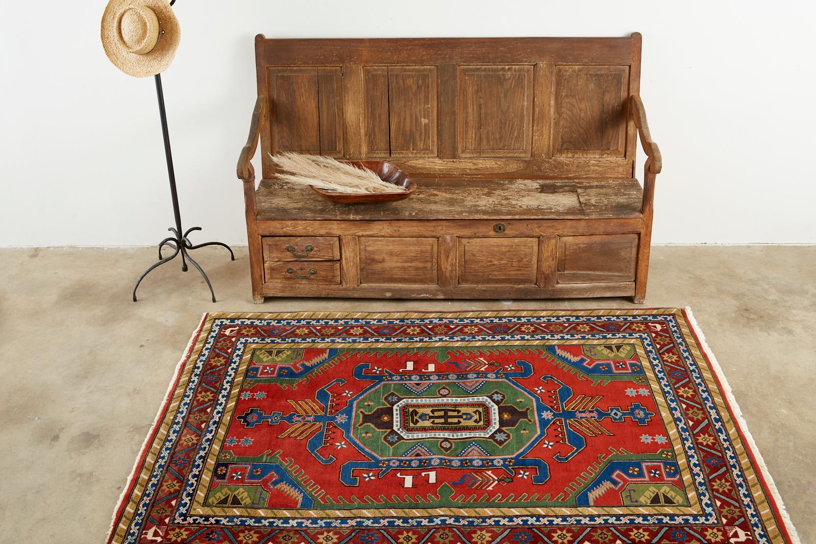 Fantastic Late 20th Century Modern semi-antique Persian Shiraz rug. Features a nomadic style typical of the Qashqai Tribe of weavers. Made with bold colors having a red field with a very rare dark green apple border. Decorated with white horse