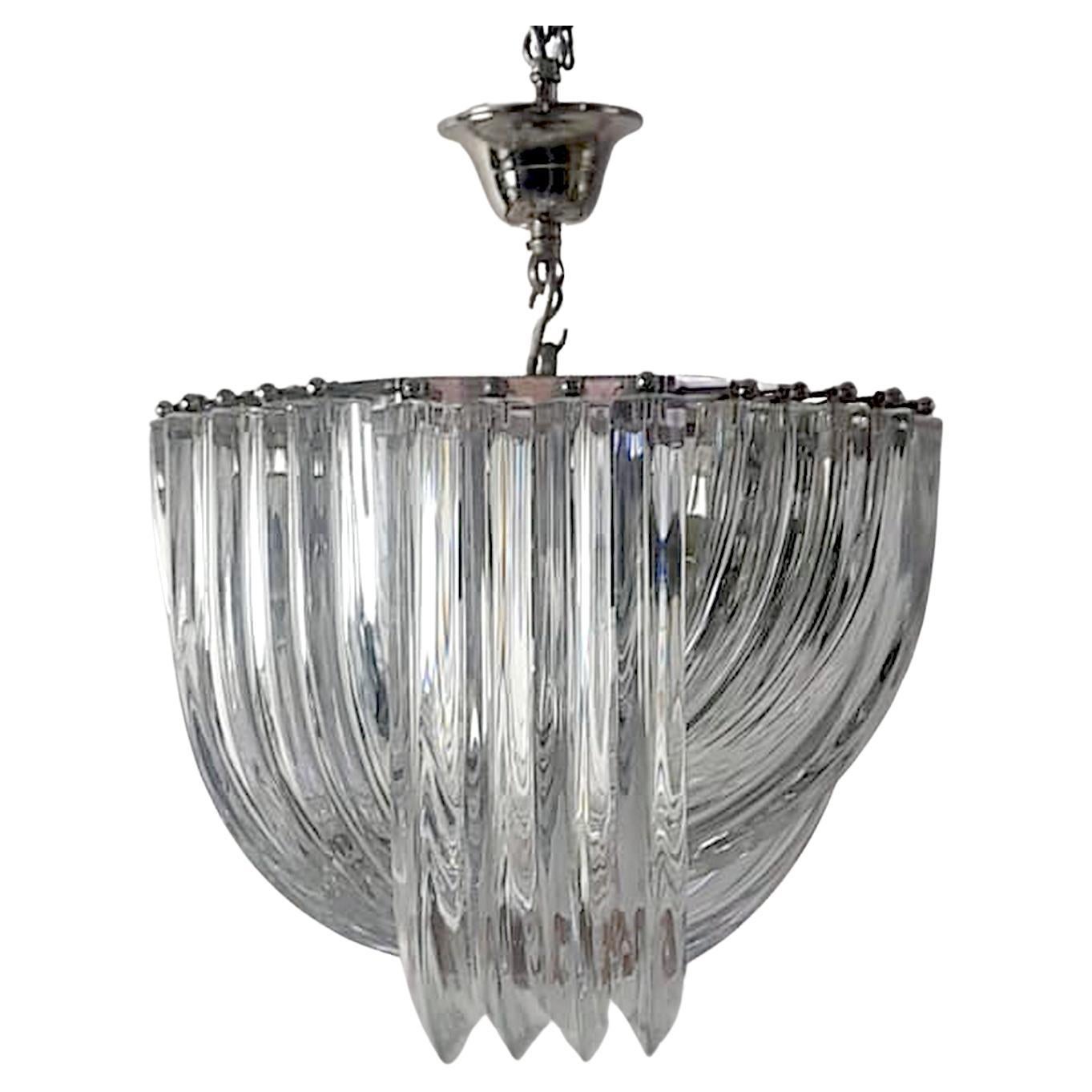 
Add a touch of classic Italian craftsmanship to your home with this stunning Venini chandelier from the 1960s. The octagonal shape and chrome structure perfectly complement the four layers of curved, handmade Triedri clear Murano glass.

Expertly