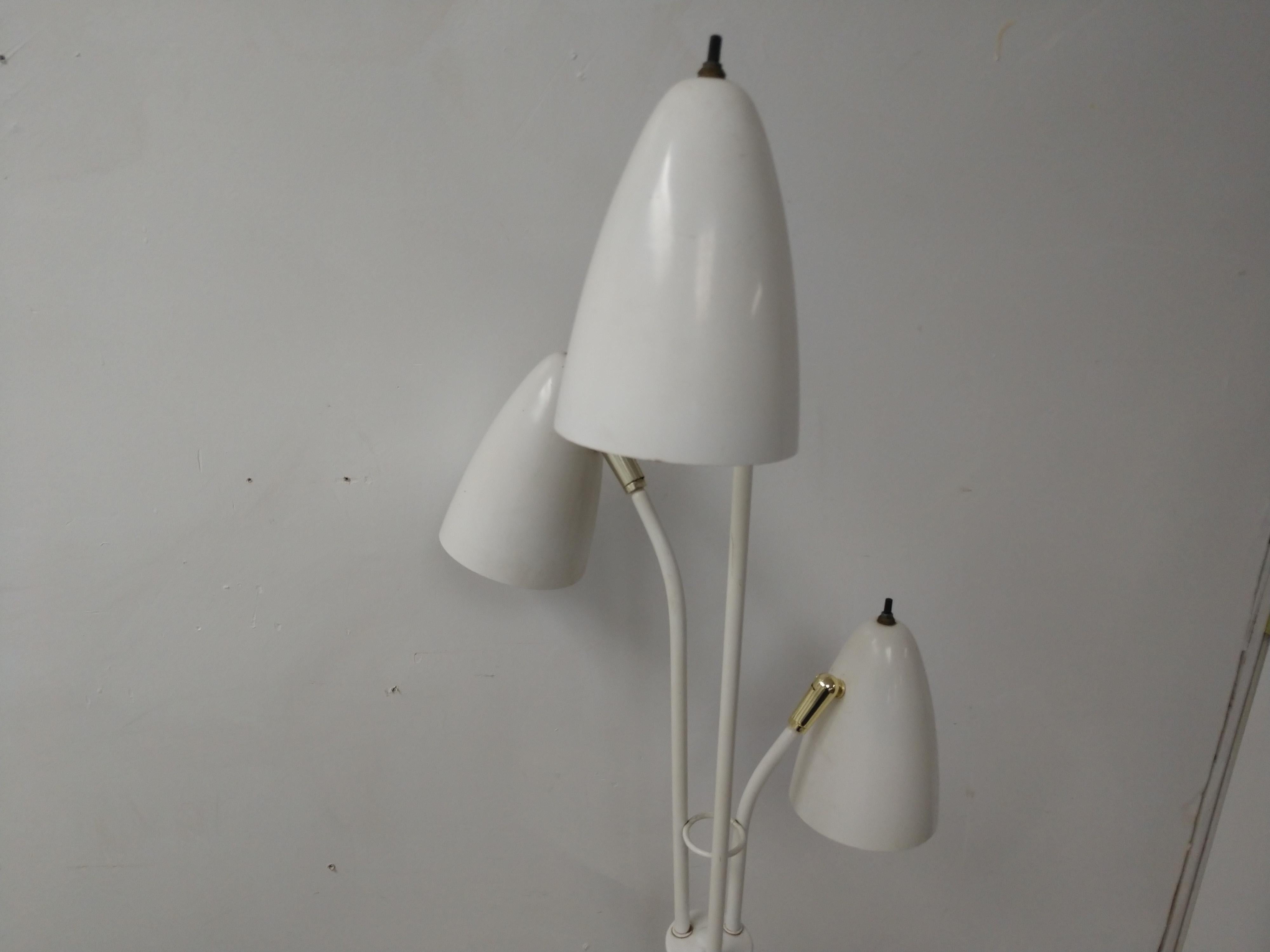 Fabulous floor lamp with three totally adjustable lamp heads. Each lamp has its own switch and can be positioned at all angles. In original condition, ivory white with brass accents. This lamp can be parcel posted.