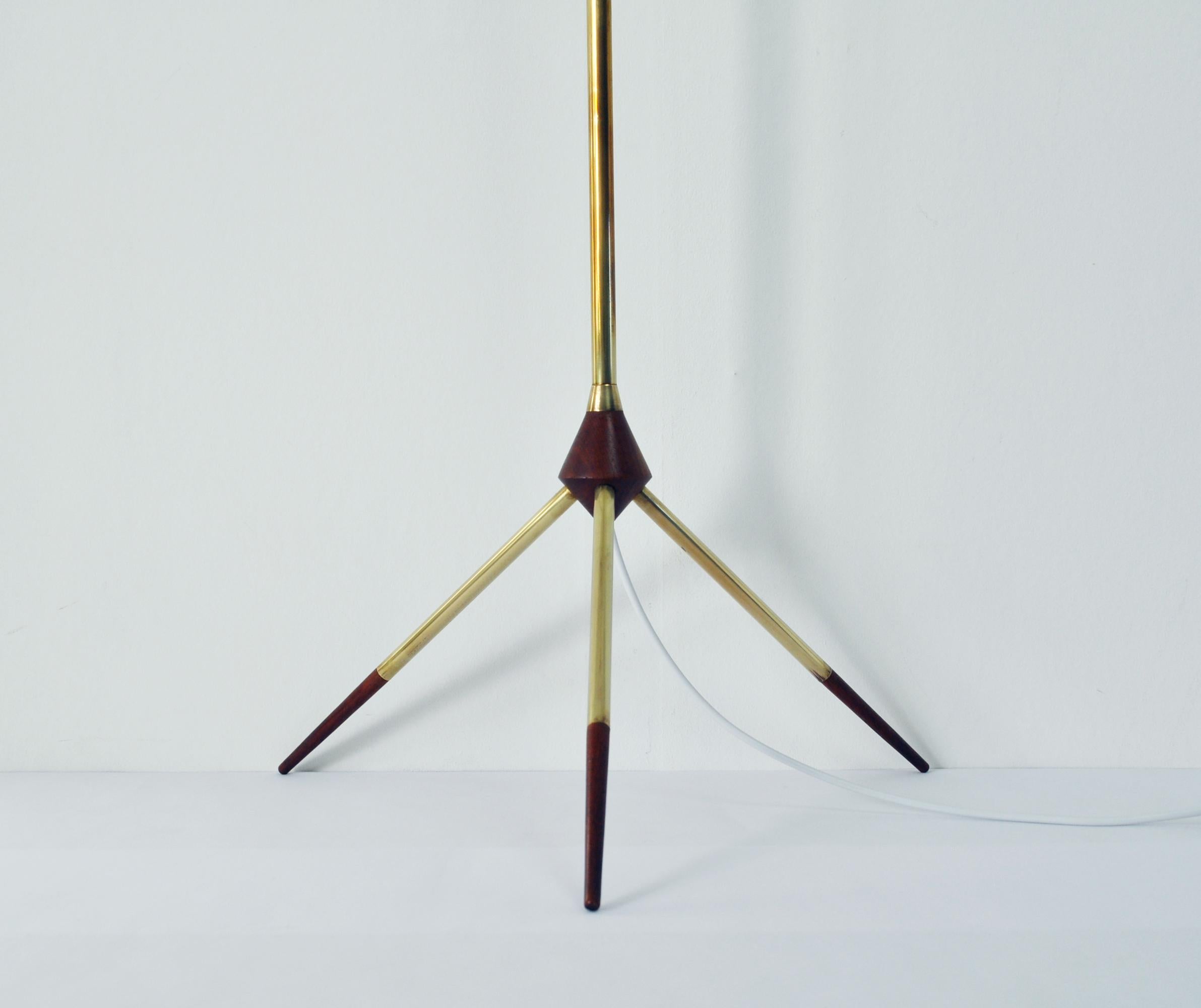 Mid-Century Modern floor lamp features a tripod brass base with teak details. 
Restored and rewired, E27 light socket.

Height with socket 122 cm, diameter circa 40 cm
This item comes without shade.