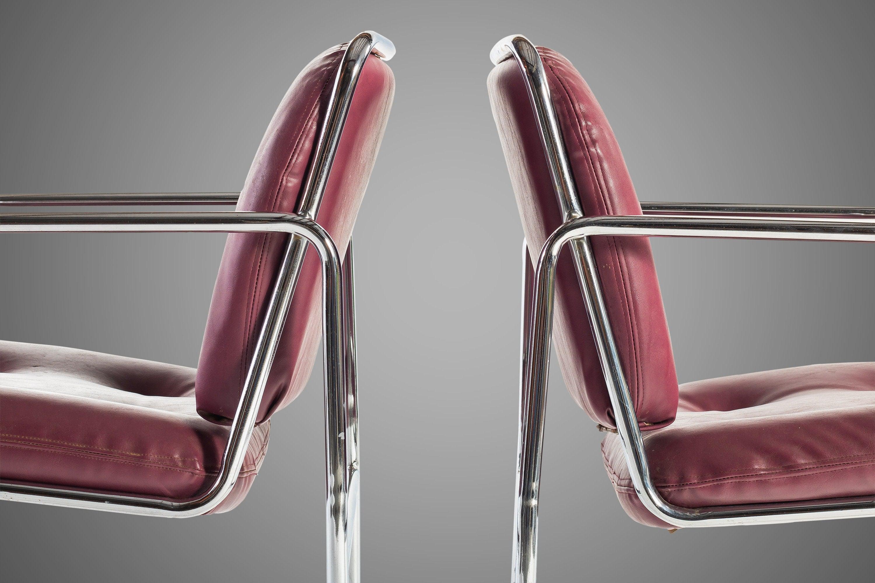Chrome plated steel tubular frames support original oxblood tufted vinyl seats. Circa 1960s.

---Dimensions---

Width: 20.25 in / 51.44 cm
Depth: 24 in / 60.96 cm
Height: 31.25 in / 79.38 cm
Seat Height: 18.5 in / 46.99 cm
Arm Height: 25.25 in /