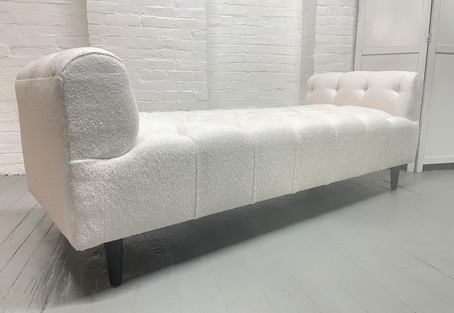 Mid-Century Modern tufted bench upholstered in Bouclé. Has black painted legs.