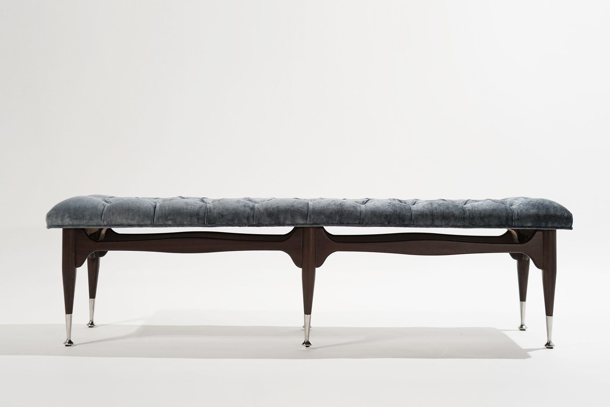 A original 1950s mid-century modern tufted bench, meticulously restored to its former glory by Stamford Modern. Crafted from solid mahogany, this timeless beauty boasts impeccable craftsmanship, complemented by nickel sabots and a sumptuous blue