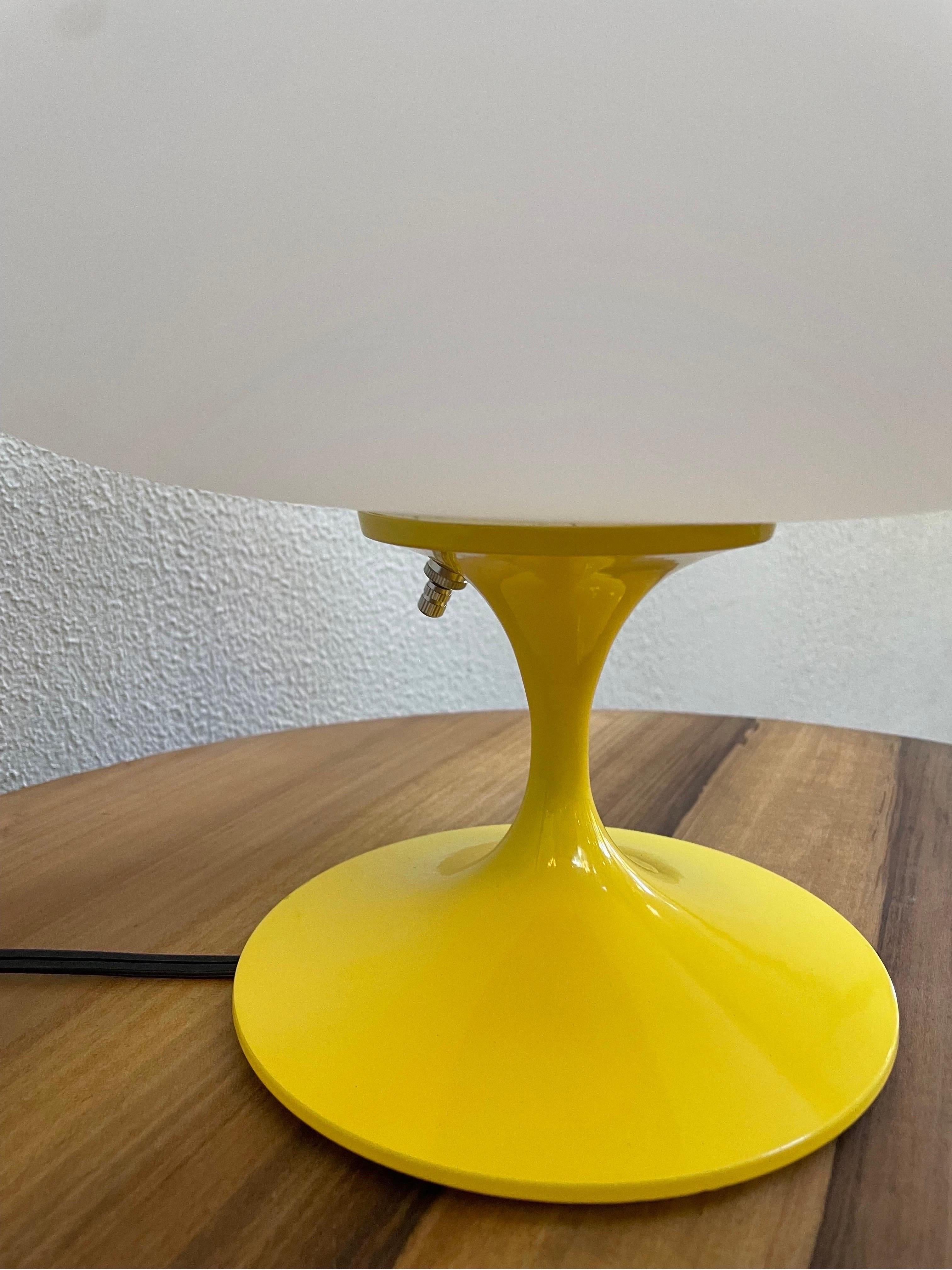 A gorgeous tulip form table lamp after Laurel Lamp company. It features a yellow powder coated cast aluminum base with mouth blown frosted white glass shades. It takes one standard bulb up to 100 watts.
