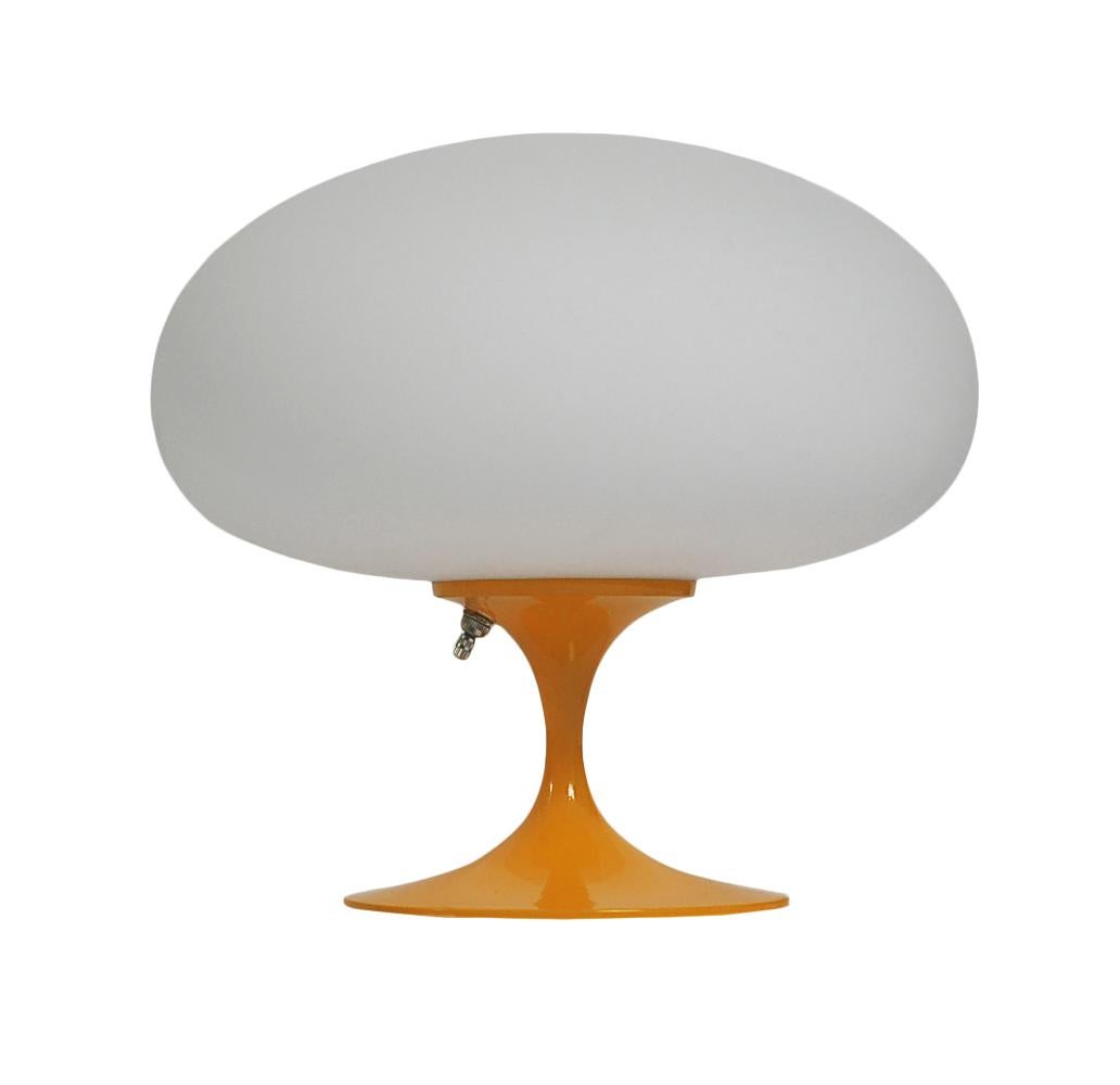 A gorgeous tulip form table lamp after Laurel Lamp company. It features a cast aluminum base in an orange powder coat with mouth blown frosted white glass shades. It takes one standard bulb up to 100 watts.