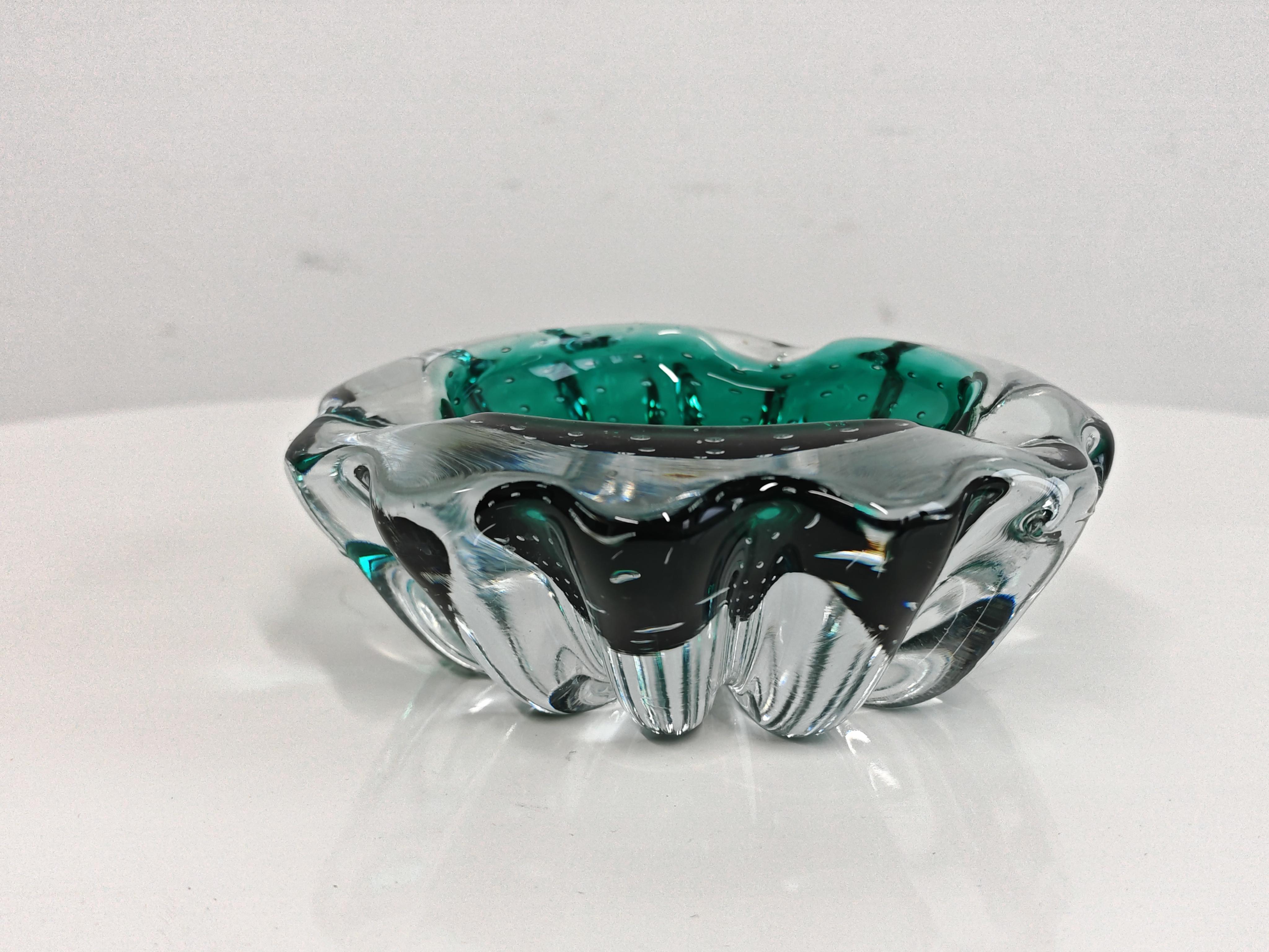 In this listing you will find a breathtaking Mid Century Modern Ashtray in Murano glass. Design is attr. to Archimede Seguso and it features the controlled air bubble technique - the small bubbles captured inside the glass, which give a playful