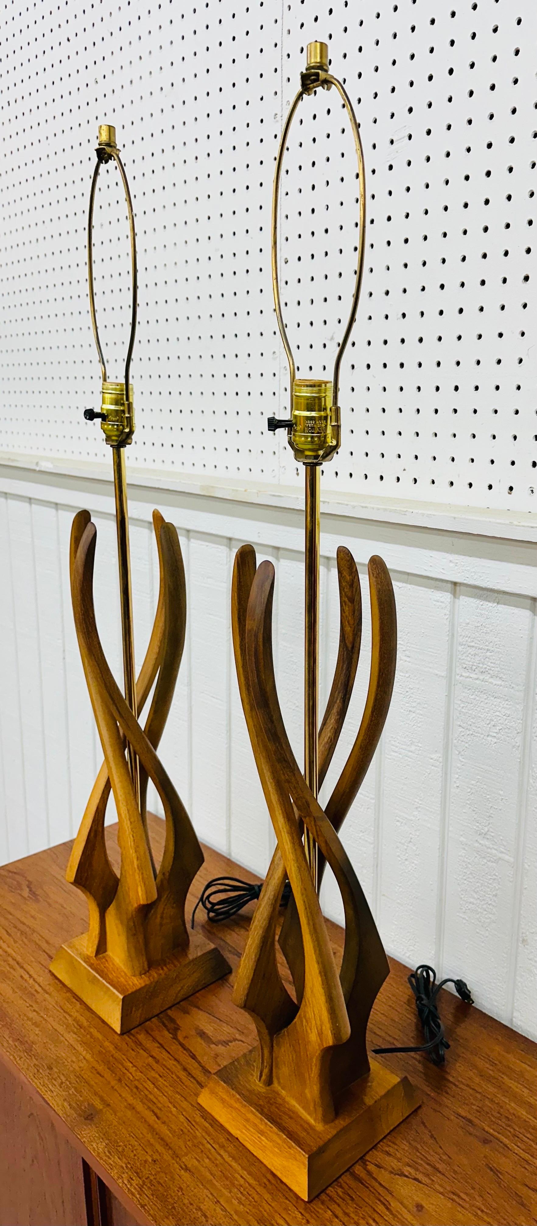 This listing is for a pair of Mid-Century Modern Twisted Walnut Table Lamps. Featuring a brutalist design, walnut base with twisted walnut wrapping around the brass body, and brass harps with caps. This is an exceptional combination of quality and