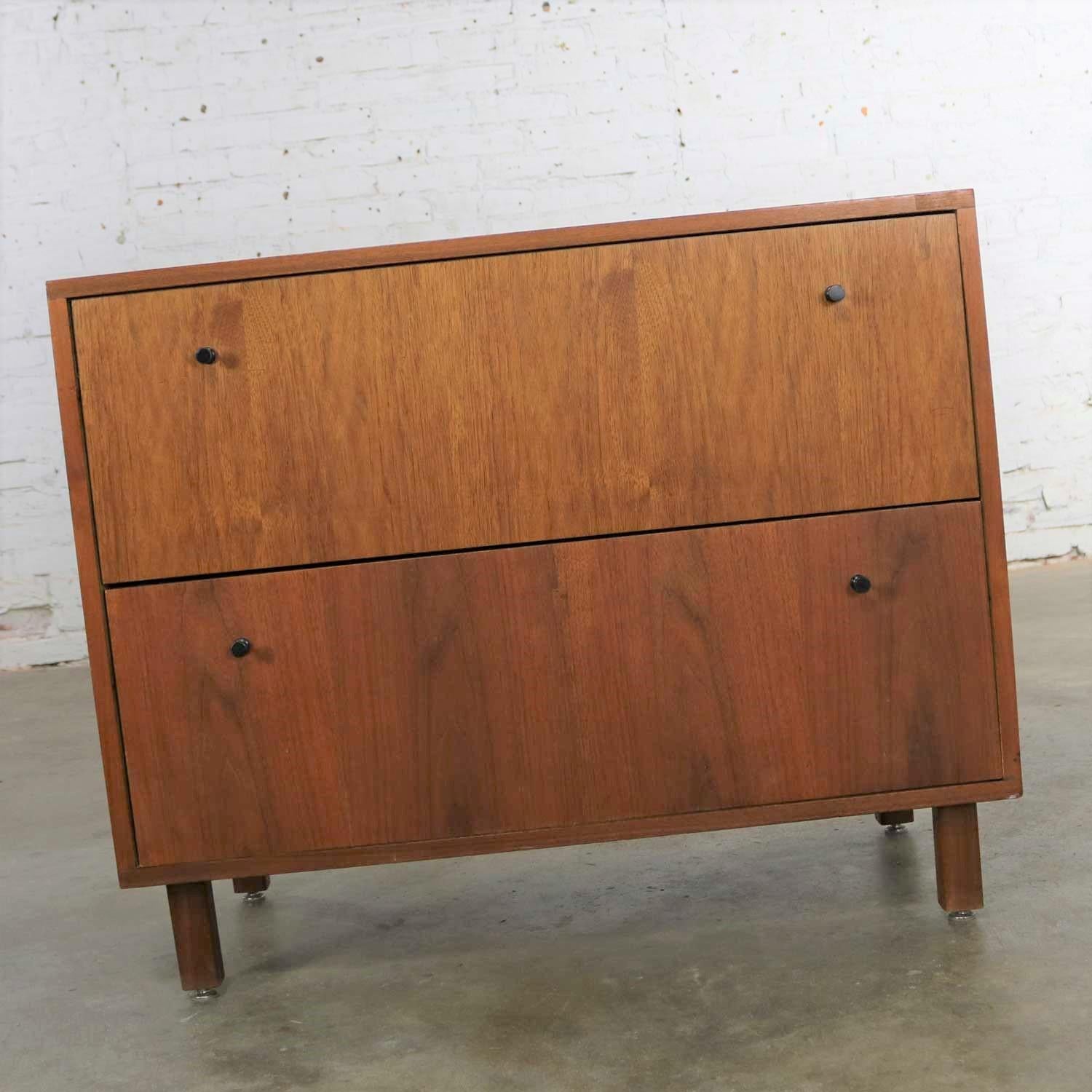 Handsome Mid-Century Modern two-drawer lateral file cabinet in walnut by Hardwood House Inc. of Rochester, New York. It is very reminiscent of cabinets by both George Nelson and Jens Risom. It is in fabulous vintage condition overall. The top drawer