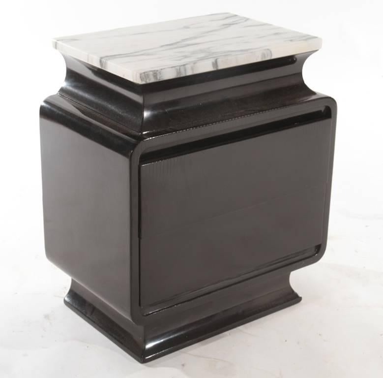 This pair of bedside tables or nightstands feature two drawers, an ebonized finish, a gorgeous honed marble top and a sculptural silhouette,  
circa 1960.
 