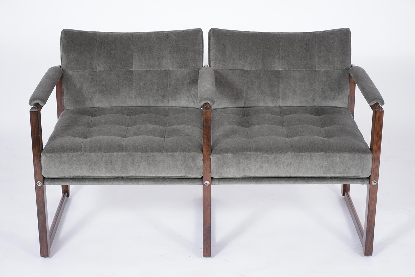 Rediscover midcentury elegance with this exquisitely restored 1960s loveseat, a handcrafted gem made from the finest rosewood. Our skilled craftsmen have revitalized this two-seater bench to its former glory, ensuring it will complement your