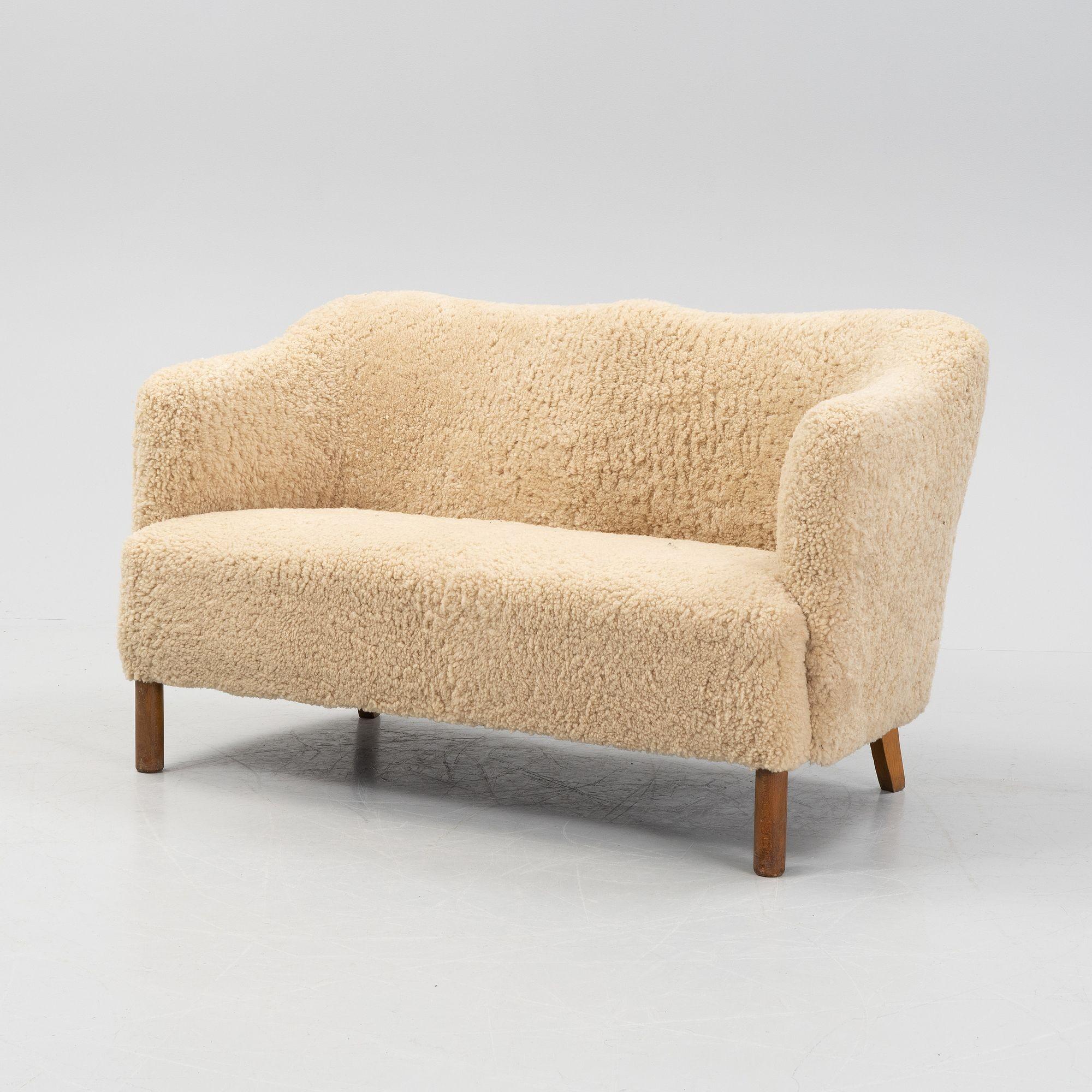 Mid-Century Modern Danish cabinet marker two-seater sofa, sheepskin, beech, Denmark, 1950s.
 
Wonderful two seater Danish modernist settee in the style of Borge Mogensen. This sofa is finished in a later genuine sheepskin upholstery; the back has