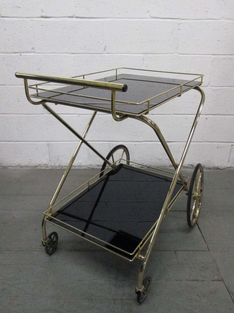 Two-tier bar cart with smoked glass tops and metal frame. Trolley.