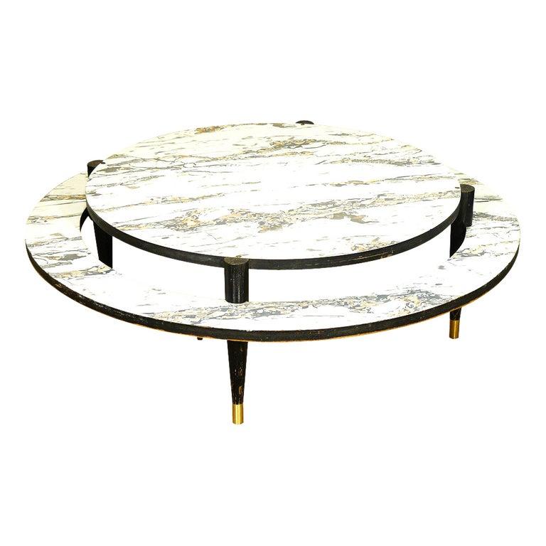 This round, Mid-Century Modern coffee table features two-tiers embellished with marbleized white Formica surfaces. The large-scale table rests on black-painted legs capped with brass foot details.
Dimensions
41.50 inches in diameter the 2nd level is