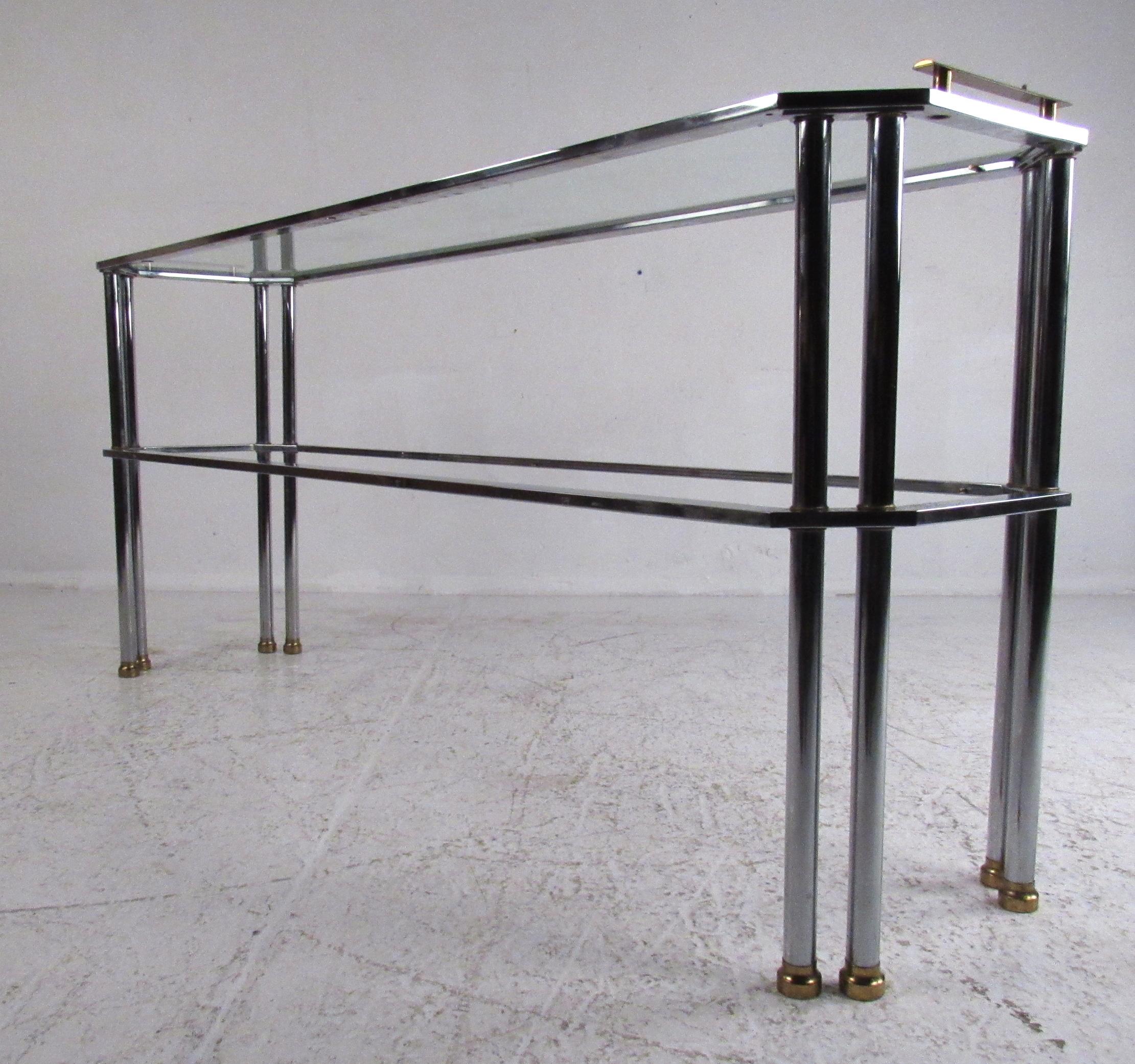 Midcentury two-tier console table in chrome with brass accents. Please confirm item location (NY or NJ) with dealer.