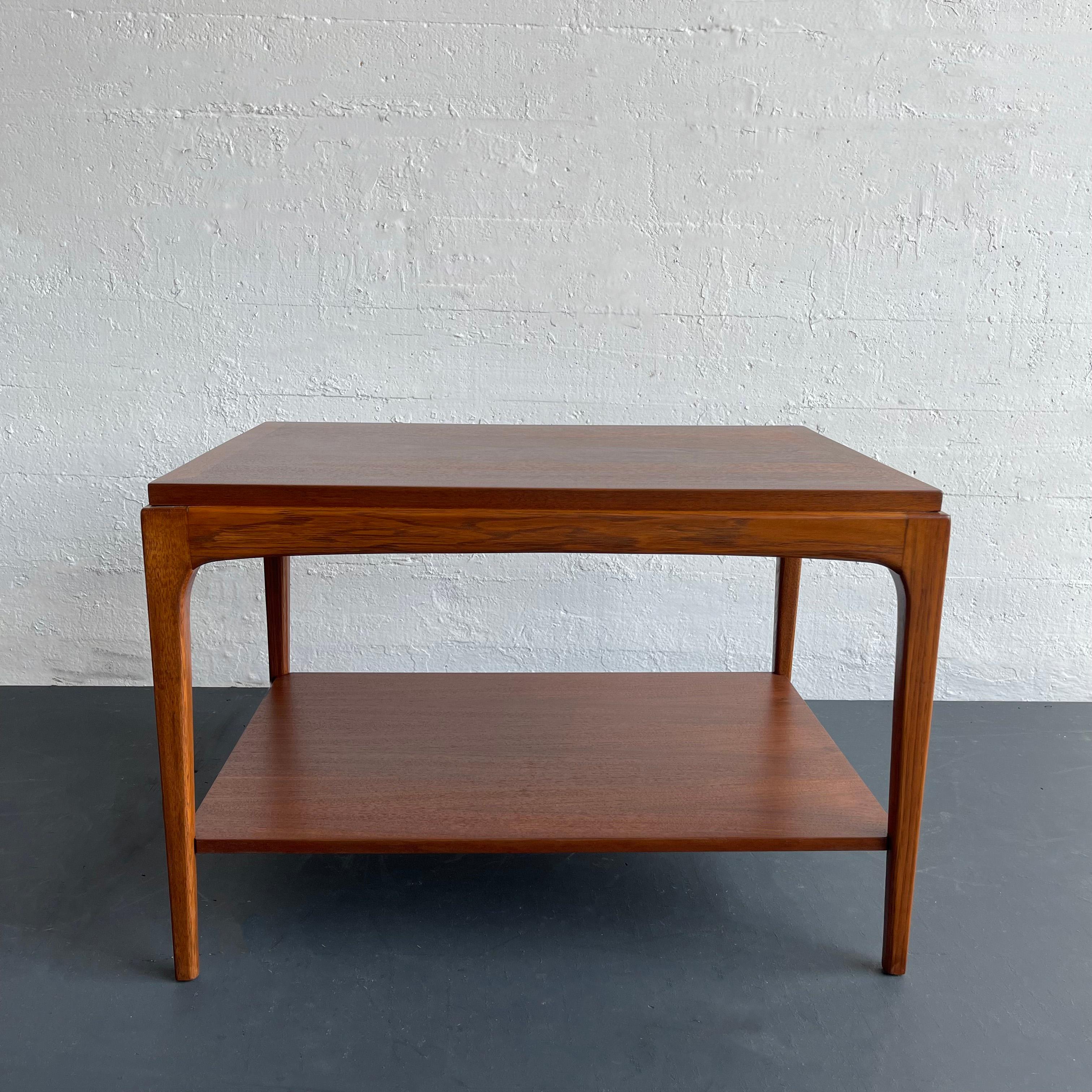 Mid-Century Modern, two-tiered, walnut, side table was manufactured by Lane Furniture in the 1960s and was part of Lane's Rhythm Collection. The Lane Brochure described its Rhythm collection as being 