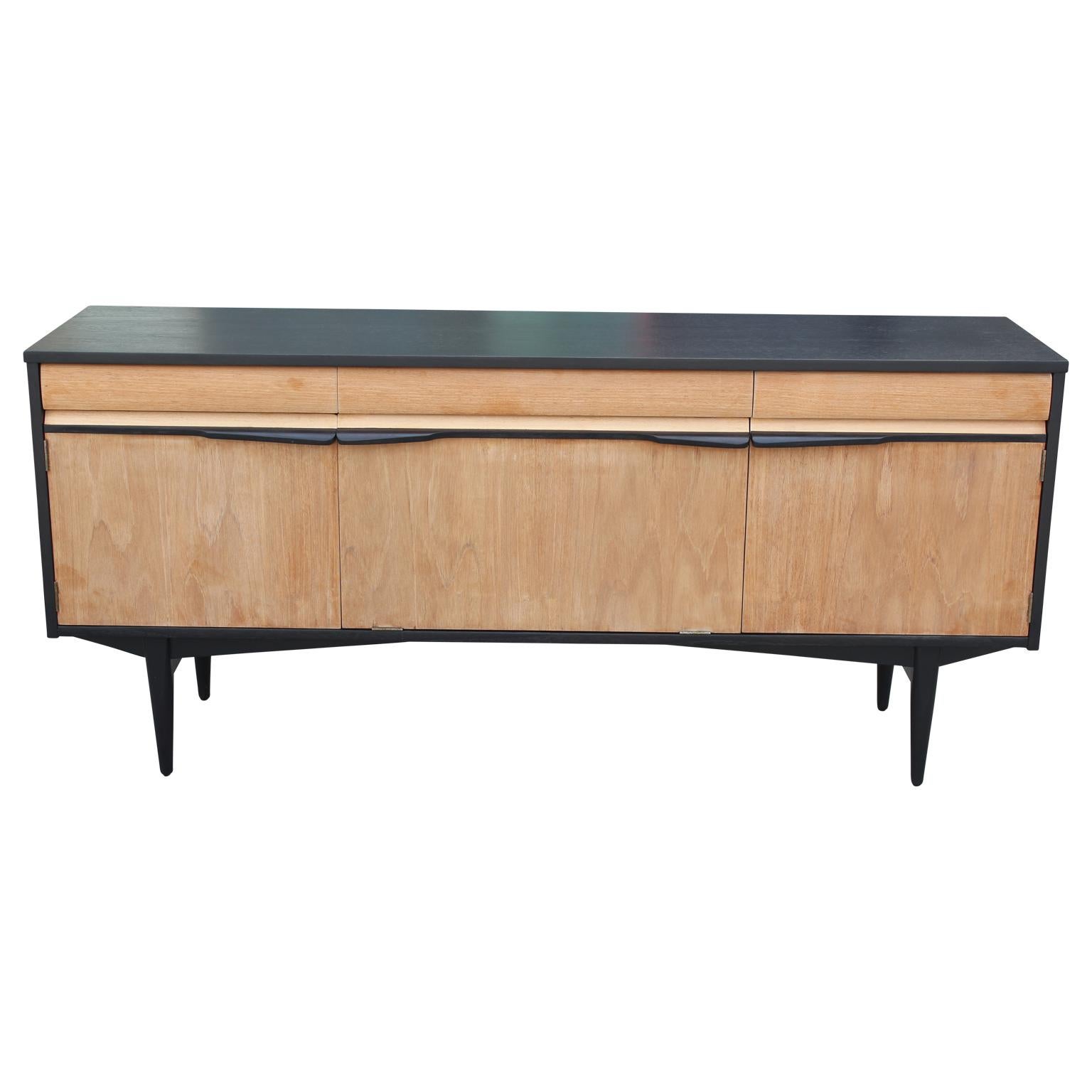 Gorgeous Mid-Century Modern credenza or sideboard featuring beautiful clean lines and freshly refinished with a two-tone look. Features three drawers across the top, one including dividers.