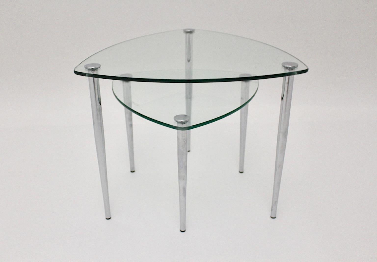 Mid-Century Modern set of 2 vintage side tables or sofa tables or stacking tables  triangle-like from clear glass and chromed screwable feet.
An amazing set of side tables or stacking tables  designed and manufactured 1960s Italy.
The stacking