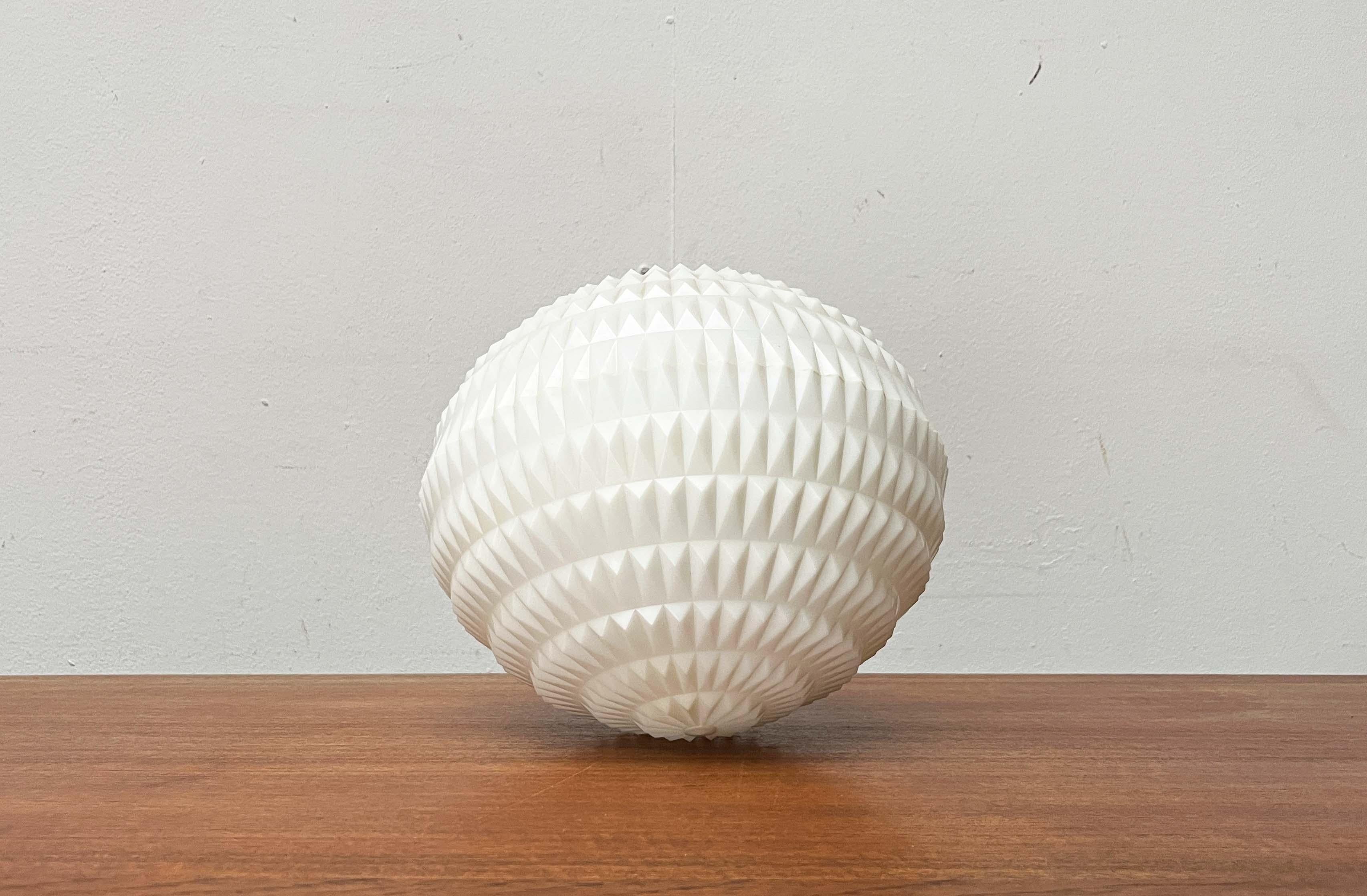 Lampada a sospensione di metà secolo di Erco, disegnata da Aloys Gangkofner.

Un design con una forma di base minimalista e una superficie complessa. Il corpo della lampada a forma di lente è realizzato in plastica traslucida. La superficie è