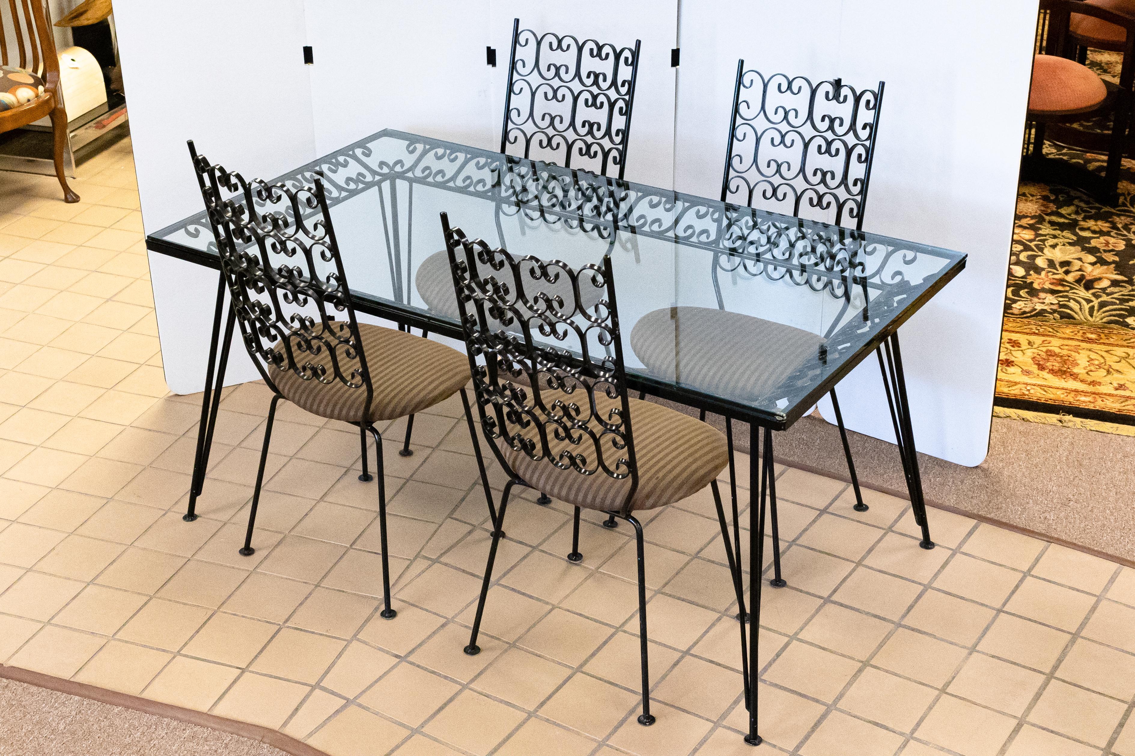 An elegant Arthur Umanoff Grenada wrought iron dinette table and chair set, can be used for indoors or outdoors. This set is in great vintage condition. This midcentury modern table has a large glass face in great condition, with only a few small