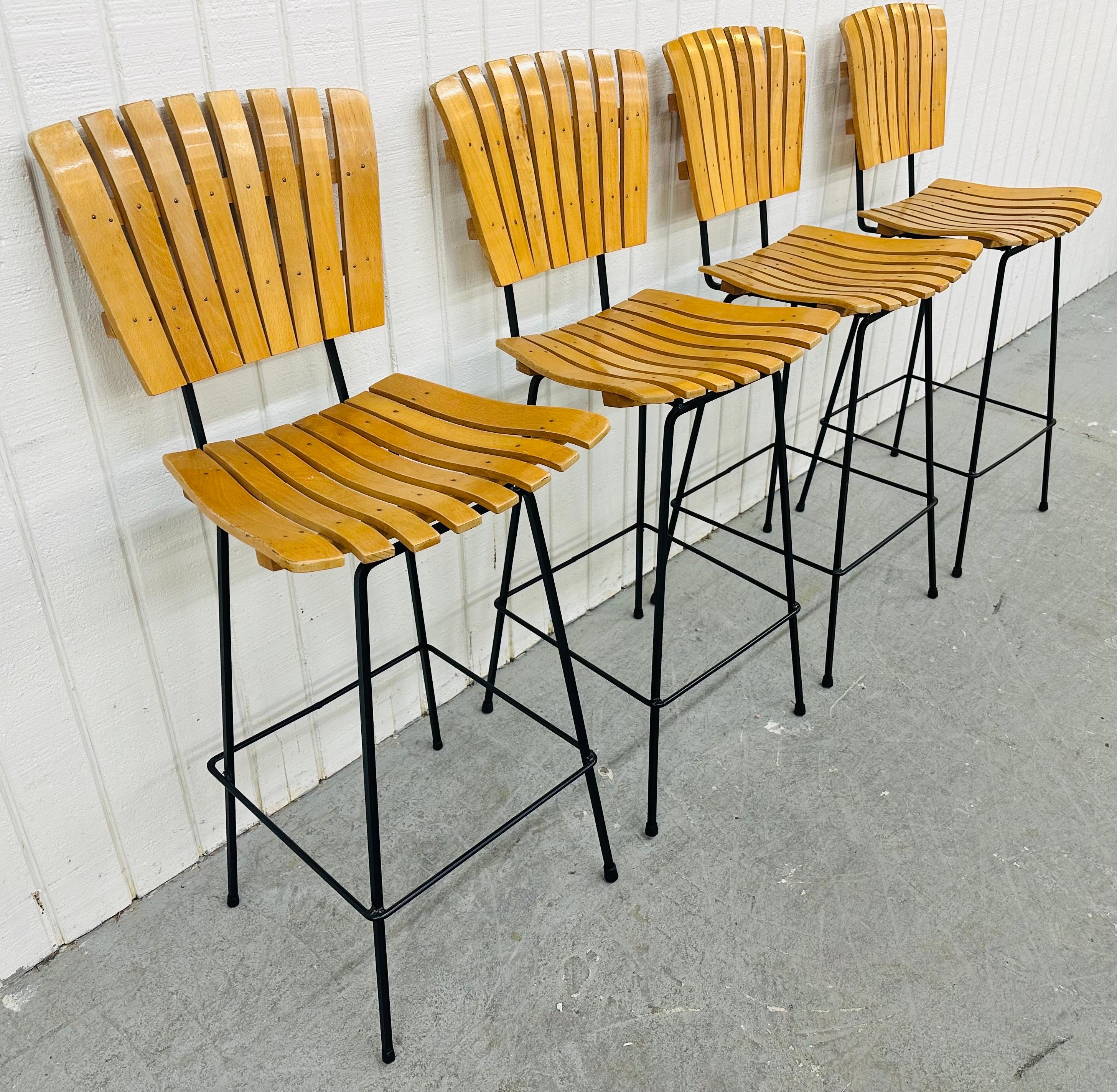 This listing is for a set of four Mid-Century Modern Umanoff Style Slatted Bar Stools. Featuring a slatted seat, backrest, and black metal modern base. This is an exceptional combination of quality and design!