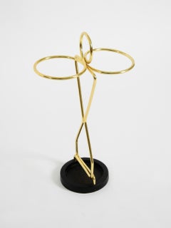 Mid-Century Modern umbrella stand featuring brass and a black cast-iron base