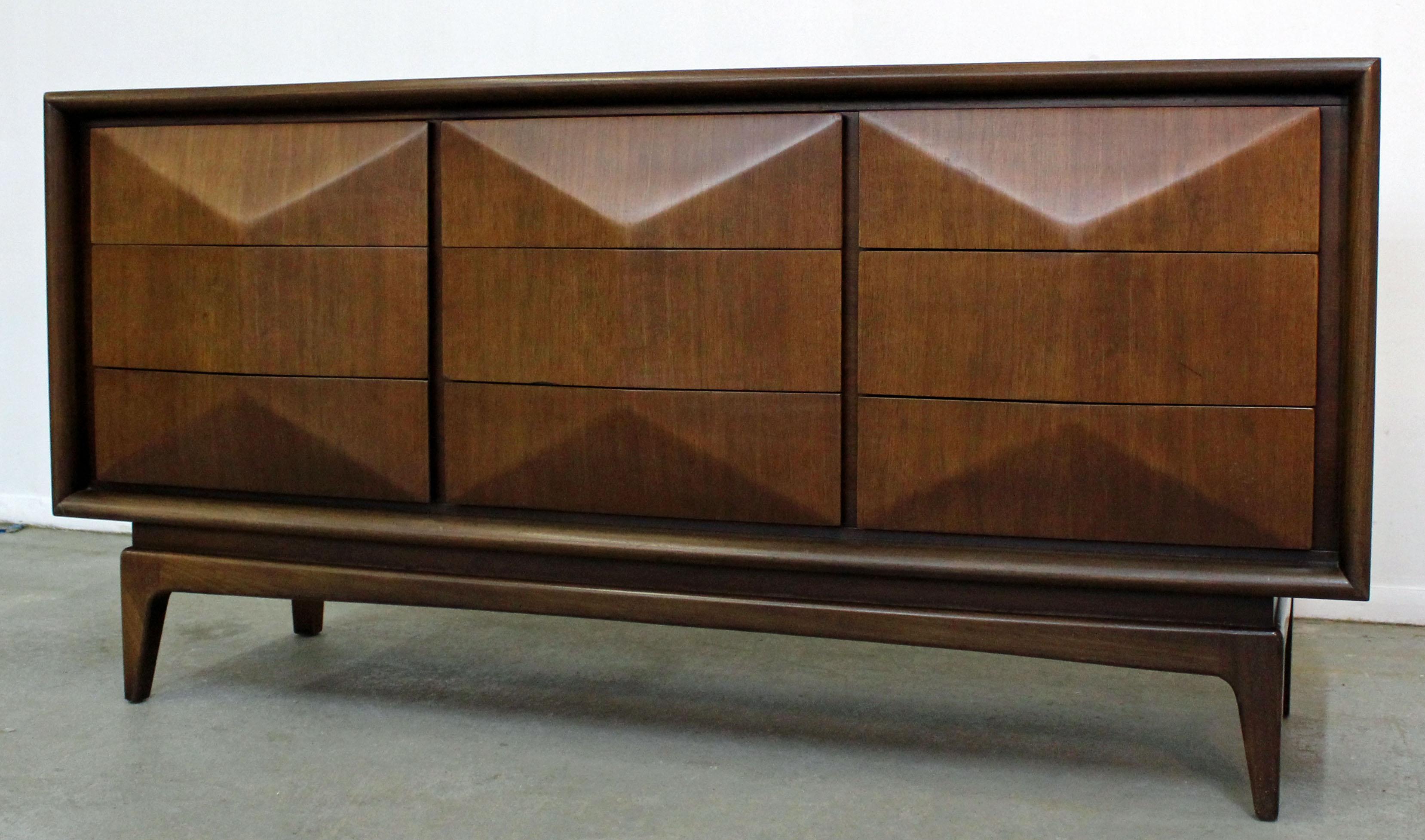 Offered is a walnut credenza/dresser made by United. Features nine dovetailed drawers with a sculpted front and hidden side pulls. It is in excellent condition, has been refinished. It is signed by United Furniture.

Dimensions:
62