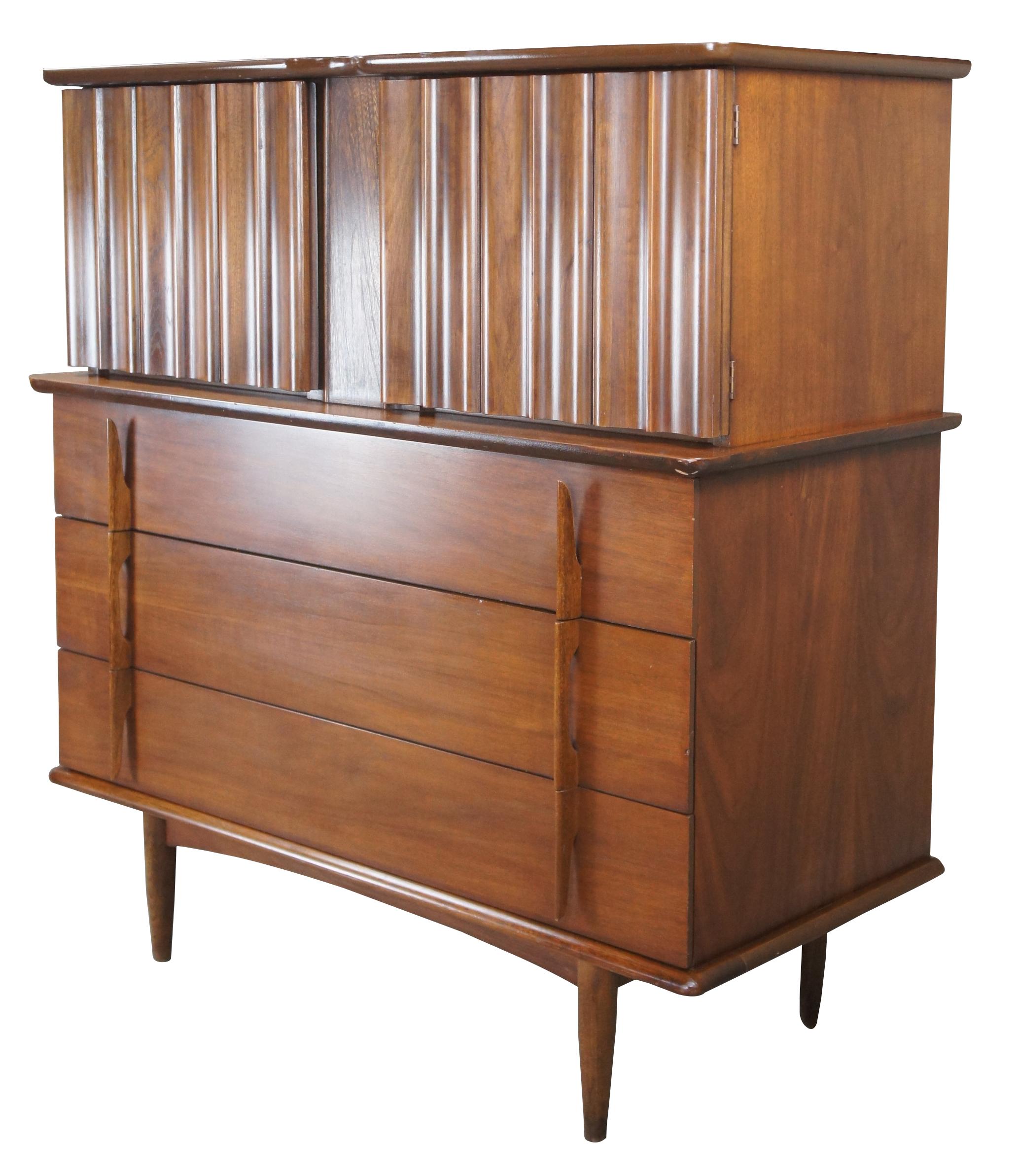 An exceptional Mid-Century Modern dresser by United Furniture Corporation. Made from walnut with a sculptural top that conceals 4 upper drawers. Lower section features three larger drawers wih sculpted drawer pulls. Each drawer is dovetailed and