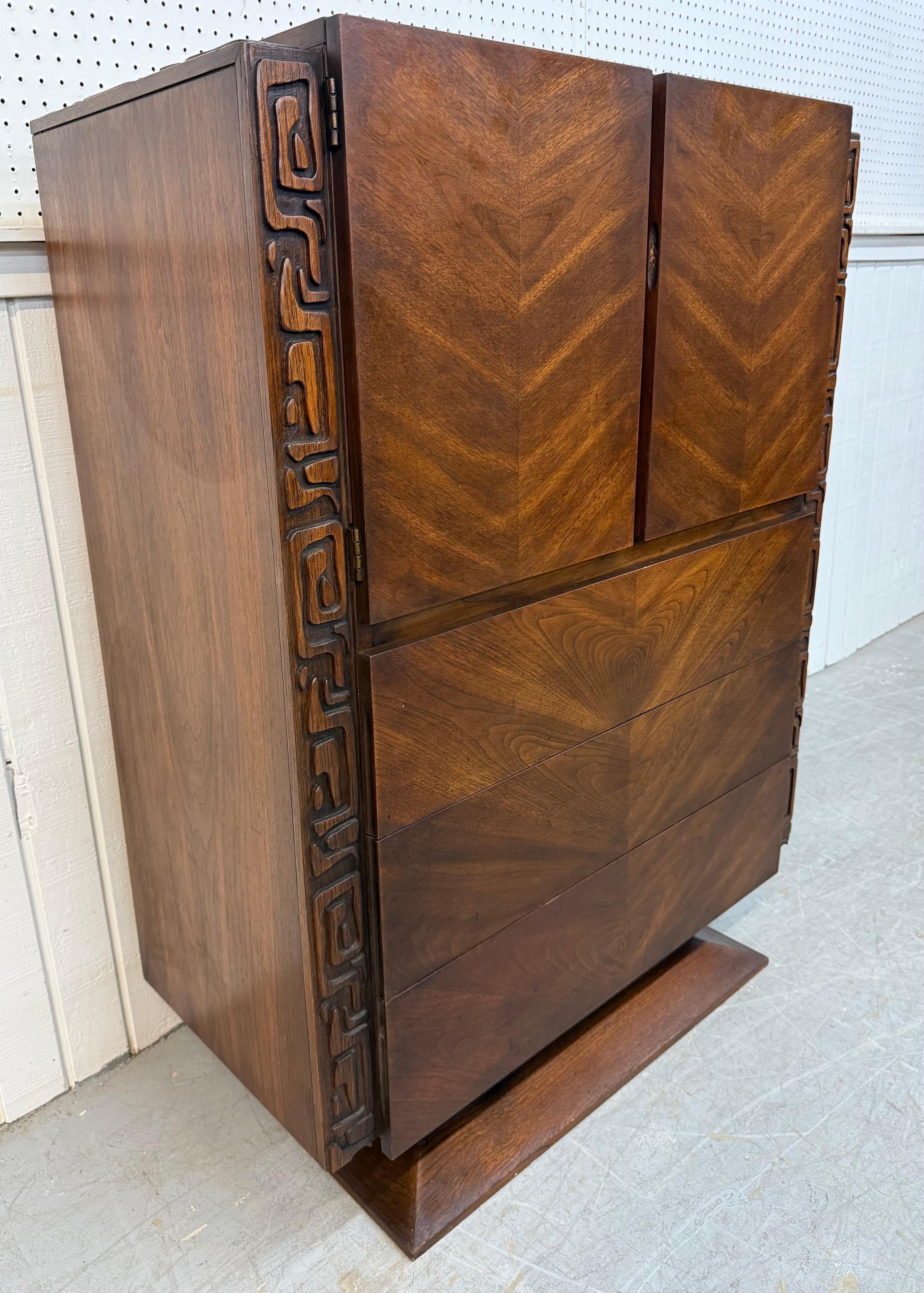 Questo annuncio si riferisce a una cassapanca in legno di noce United Tiki, un'opera moderna di metà secolo. Caratterizzata da un design brutalista dalle linee rette, due ante che si aprono per creare uno spazio di archiviazione, tre ampi cassetti