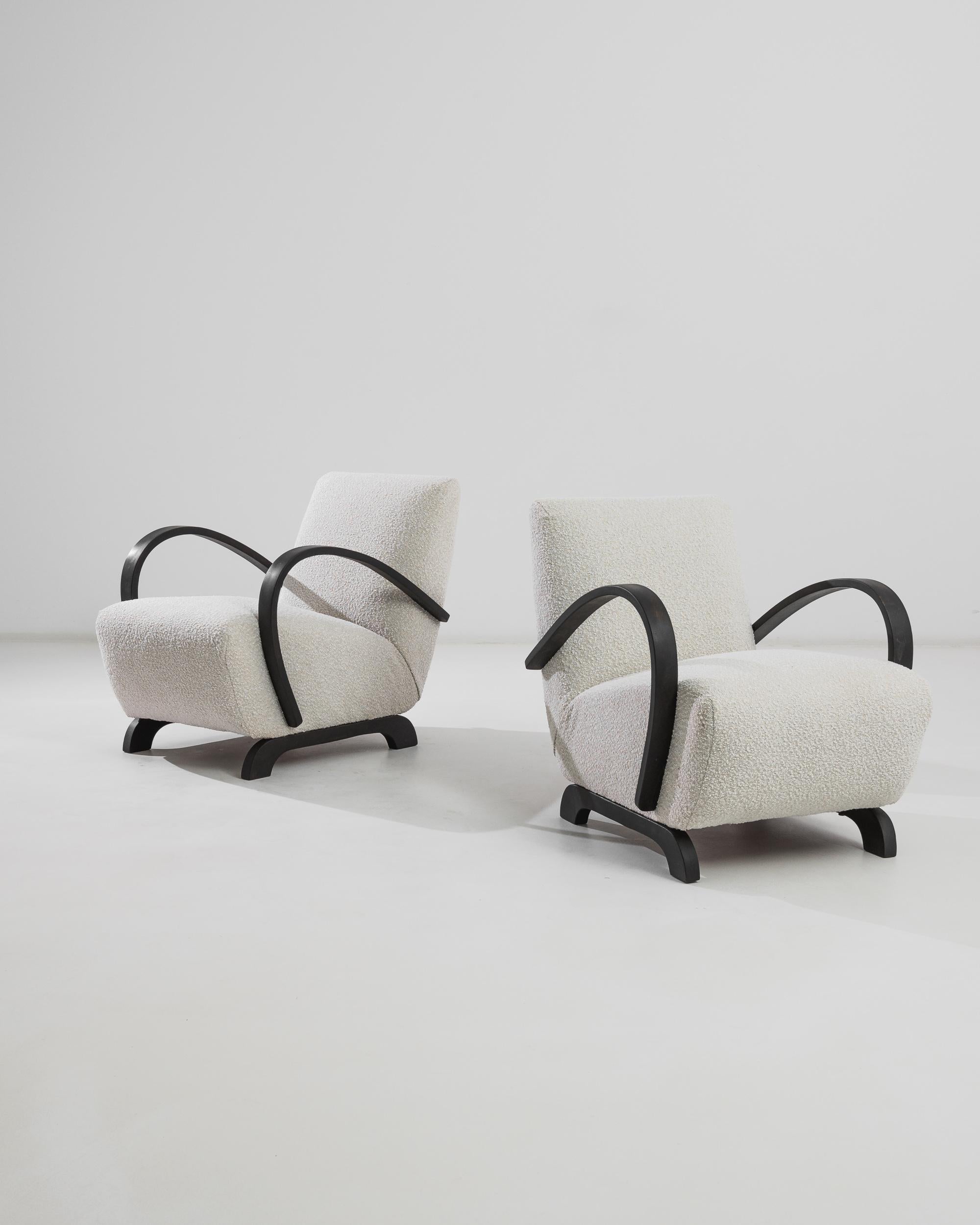 Classic black bentwood combines with reupholstered white bouclé in this iconic design by J. Halabala. Manufactured in Czechia circa 1950, these mid-century modern pieces flaunt a striking play of contrasts in colors, textures and shapes. While black