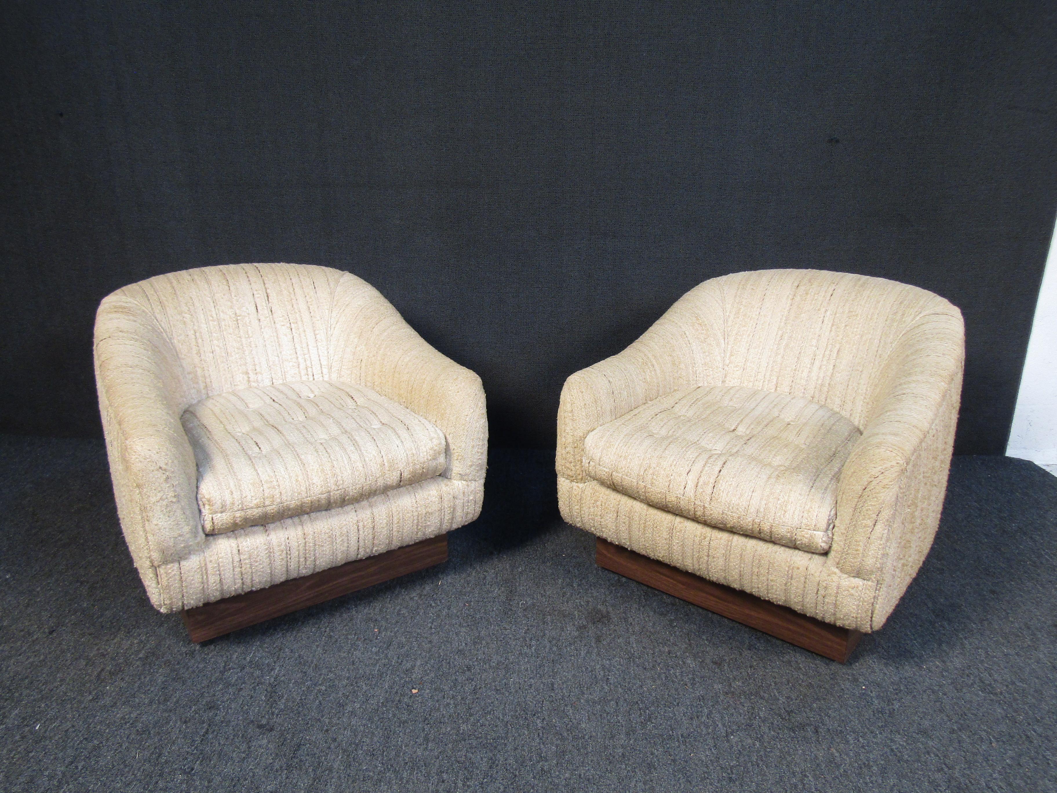 A pair of stylish Mid-Century Modern club chairs with thick upholstery and elegant wooden bases. Please confirm item location with seller (NY/NJ).