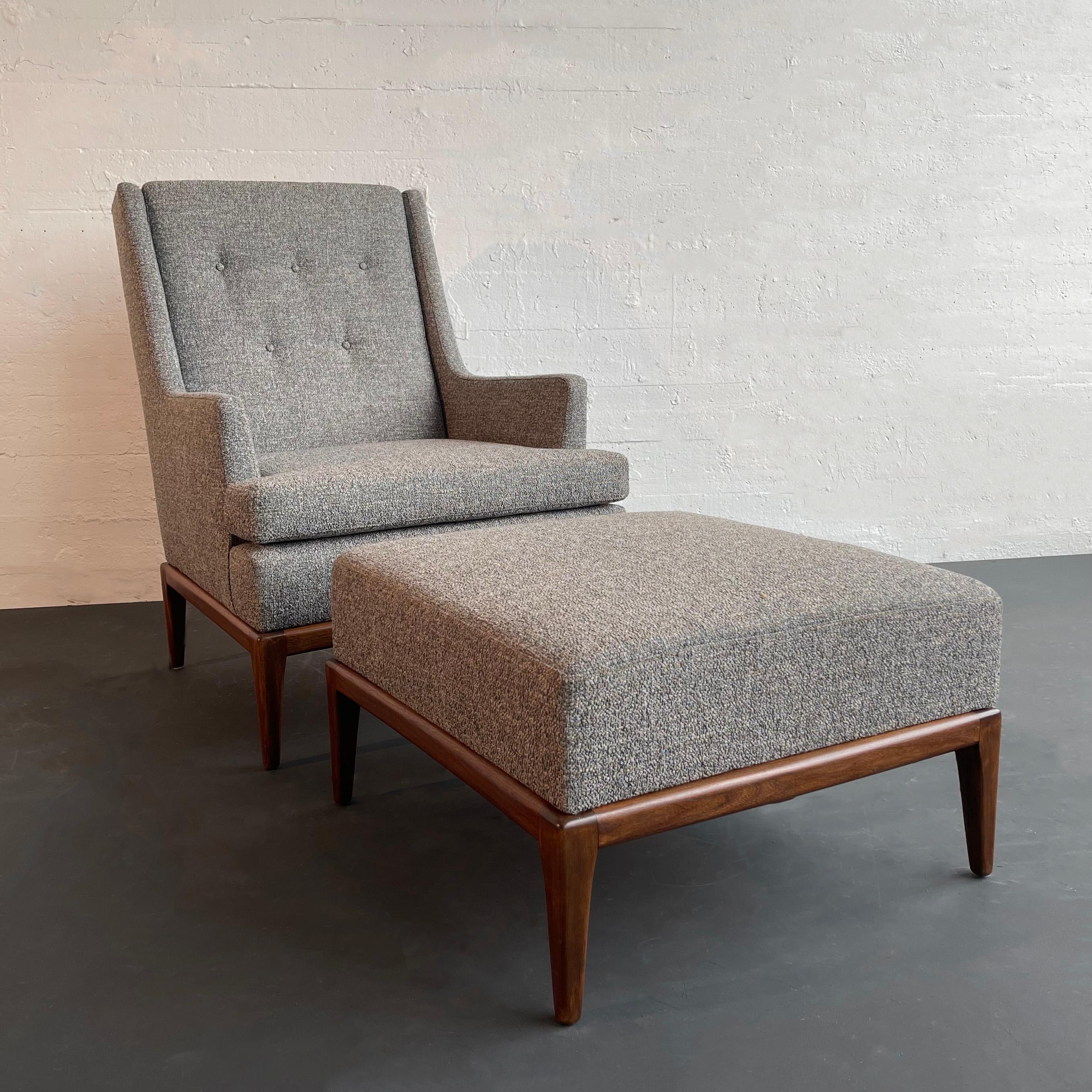 This mid-century modern lounge chair with matching ottoman features a classic, high-back profle in the manner of Paul McCobb or Milo Baughman with a fully upholstered, double cushion body and sloped recessed arms. The medium toned, sculpted solid