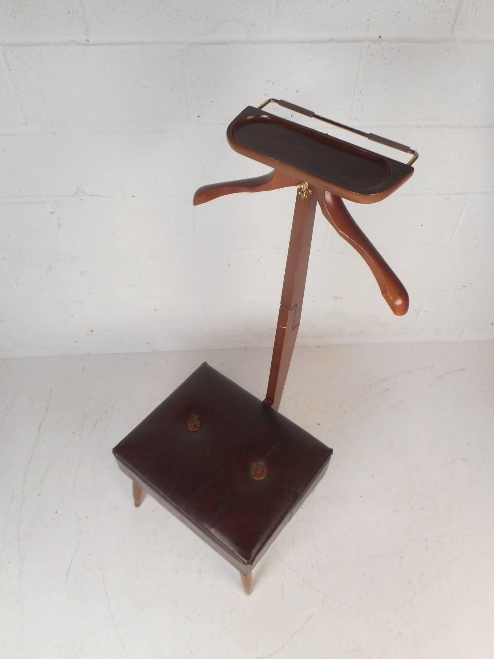 This beautiful vintage modern butler chair features a thick padded seat that opens up to unveil a large storage compartment. A sleek design with a hanger on the top for coats, a tray for small items, and a rod for ties. A thick padded seat covered