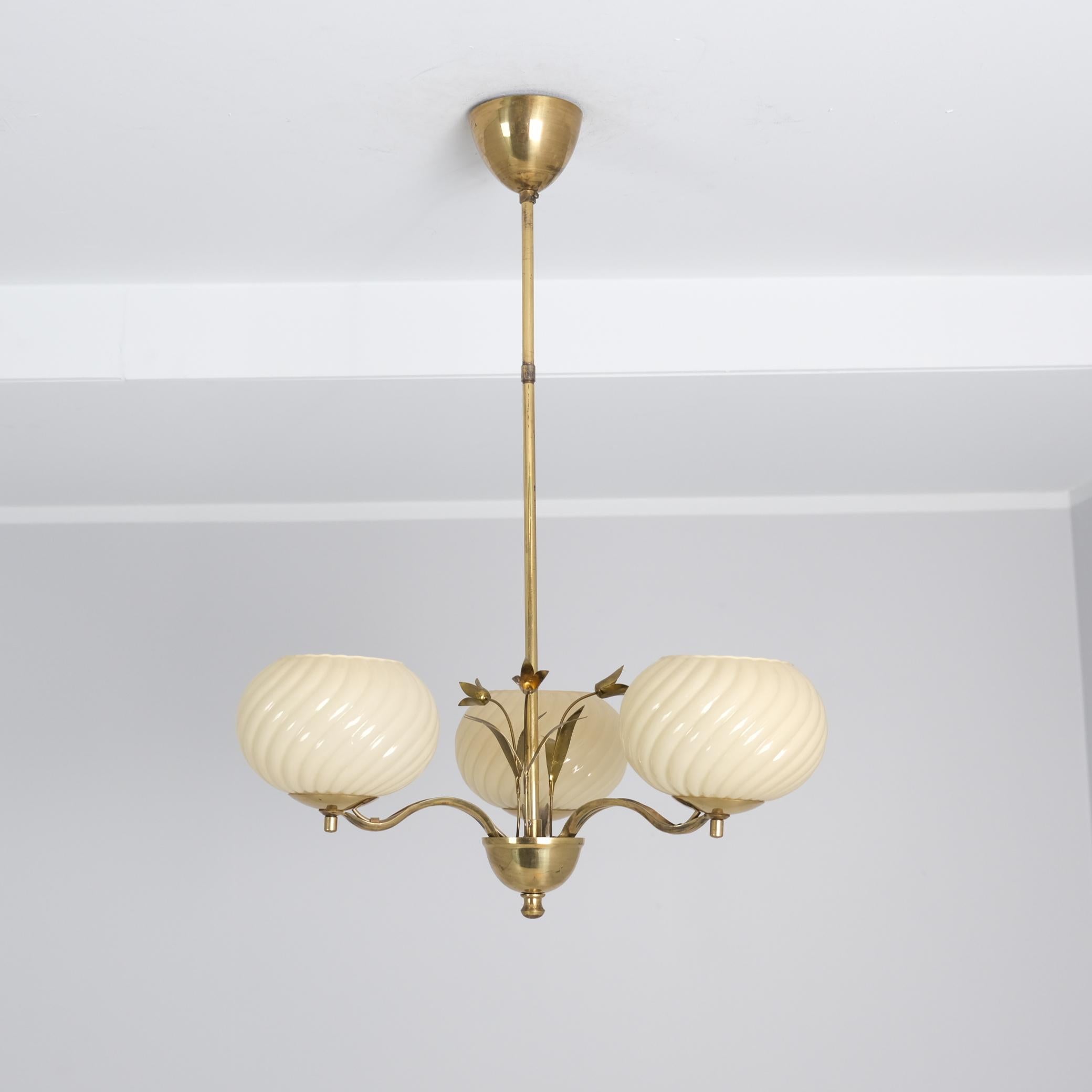 Una bellissima e delicata lampada da soffitto finlandese di metà secolo di Valinte, risalente agli anni '50, che era uno dei principali produttori di illuminazione in Finlandia. La lampada presenta tre basi luminose con paralumi in vetro opalino. Il