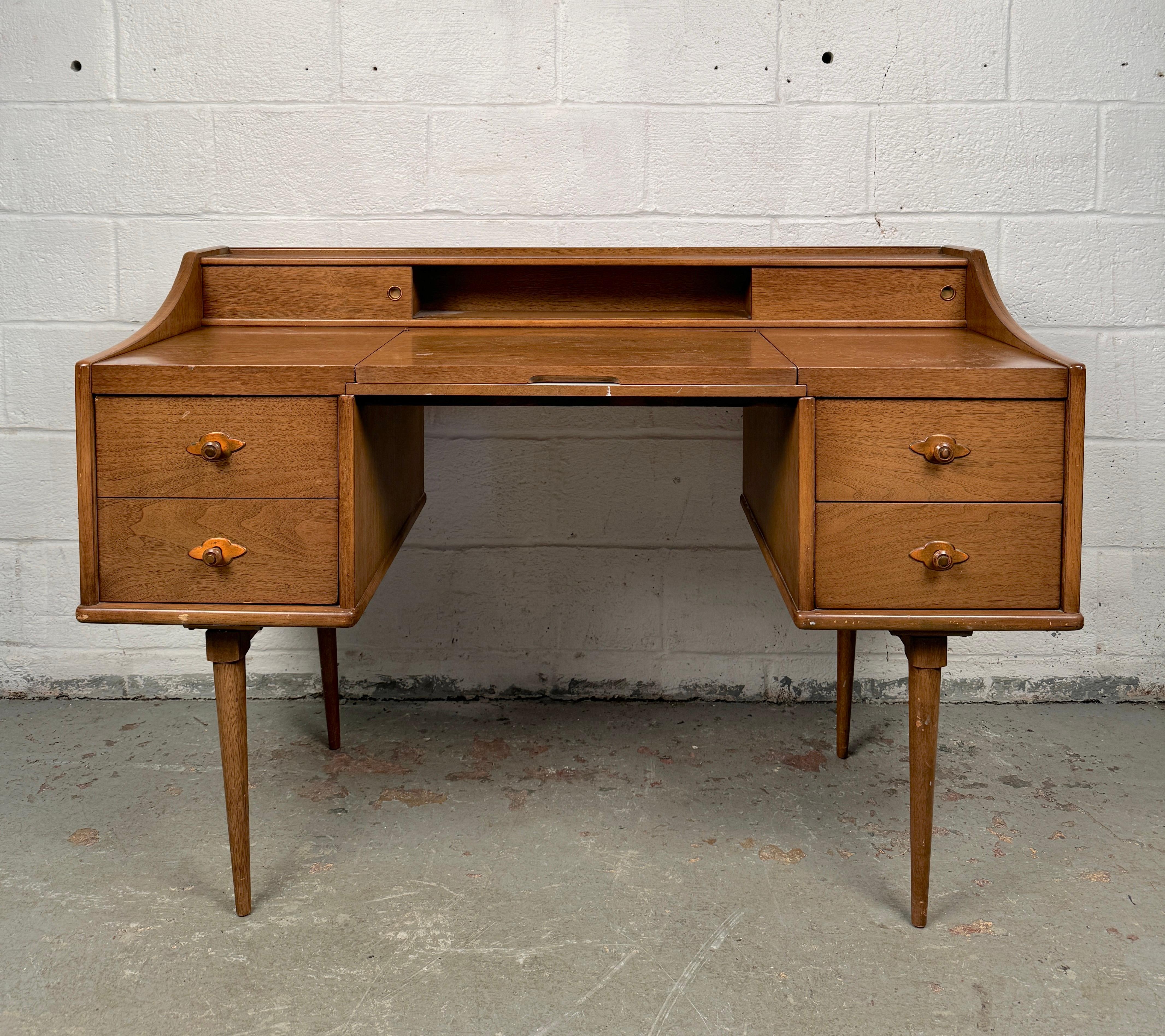 Élevez votre routine quotidienne avec ce superbe bureau de toilette moderne du milieu du siècle avec miroir de Broyhill, un nom célèbre dans le design de meubles américains. Avec ses lignes épurées, ses tons de bois chauds et ses proportions