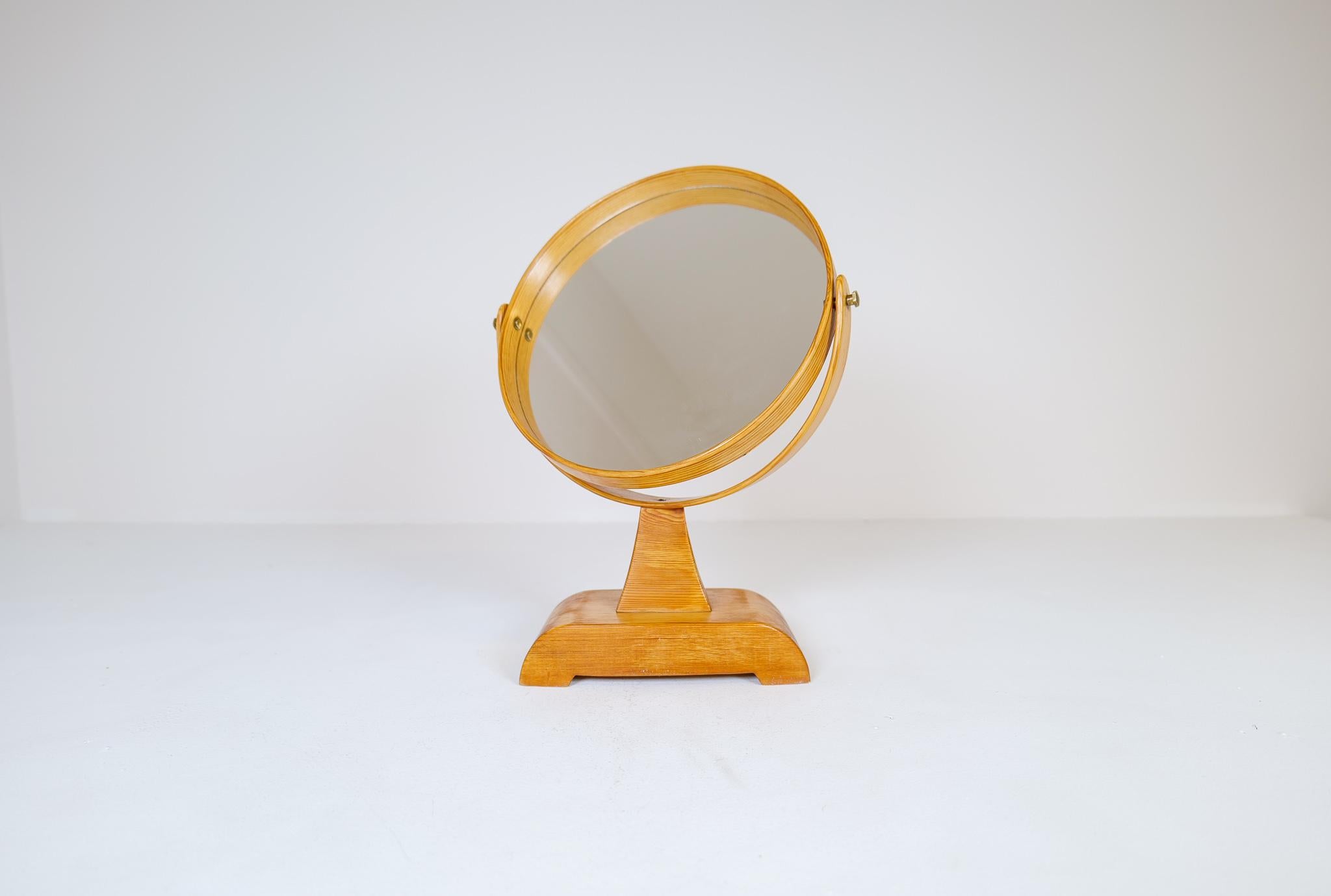 This midcentury table mirror in solid pine was produced in Sweden durig the 1970s. 
The grain of the wood in the rounded parts of the mirror is wonderful and the bade with its patina gives a great character to this unusual mirror. Turn able and