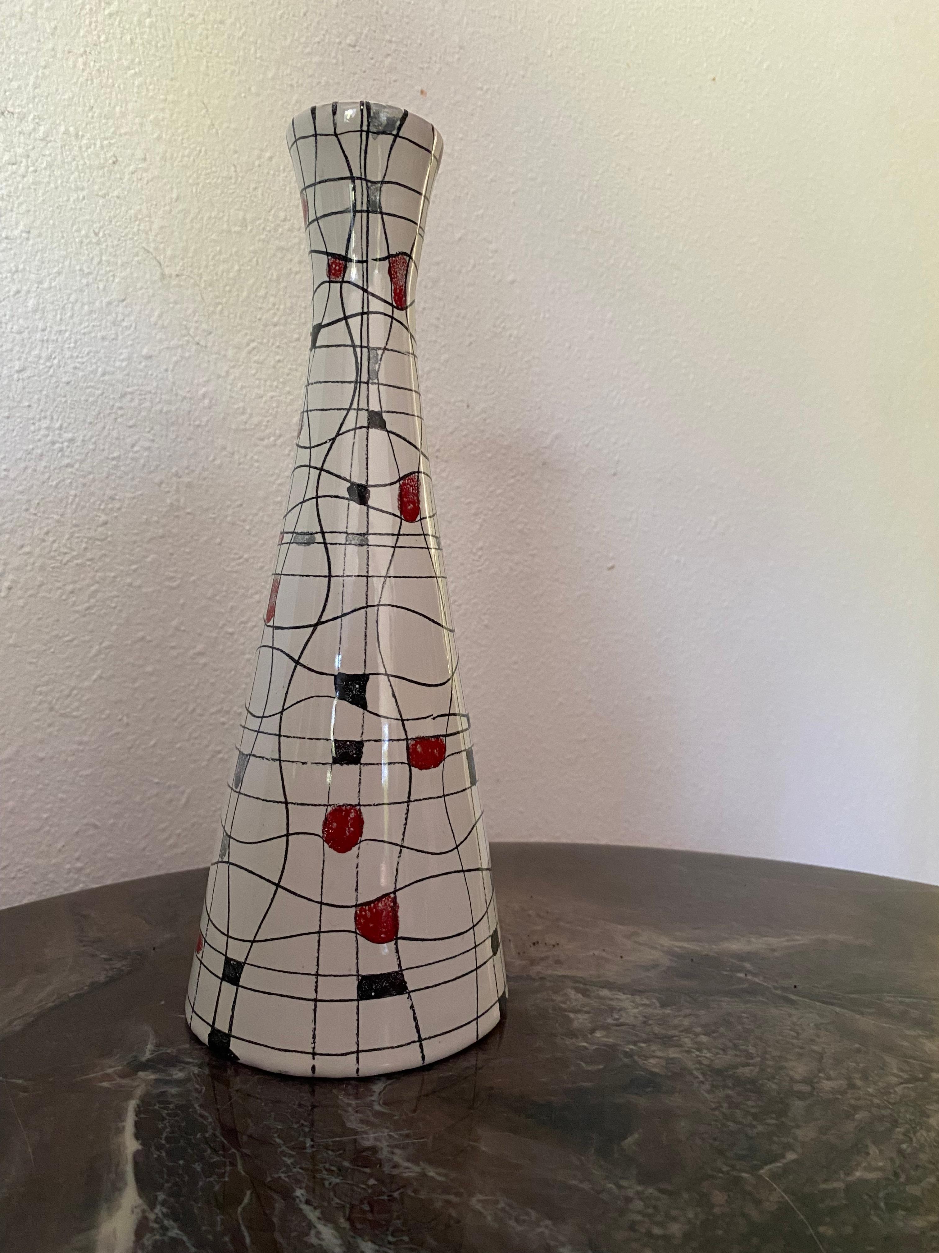 A Mid-Century Modern Bistossi ceramic vase with a stylized crossword design of squiggly lines with block squares in red, yellow, gray blue and black on a white glazed soft textured background. 
